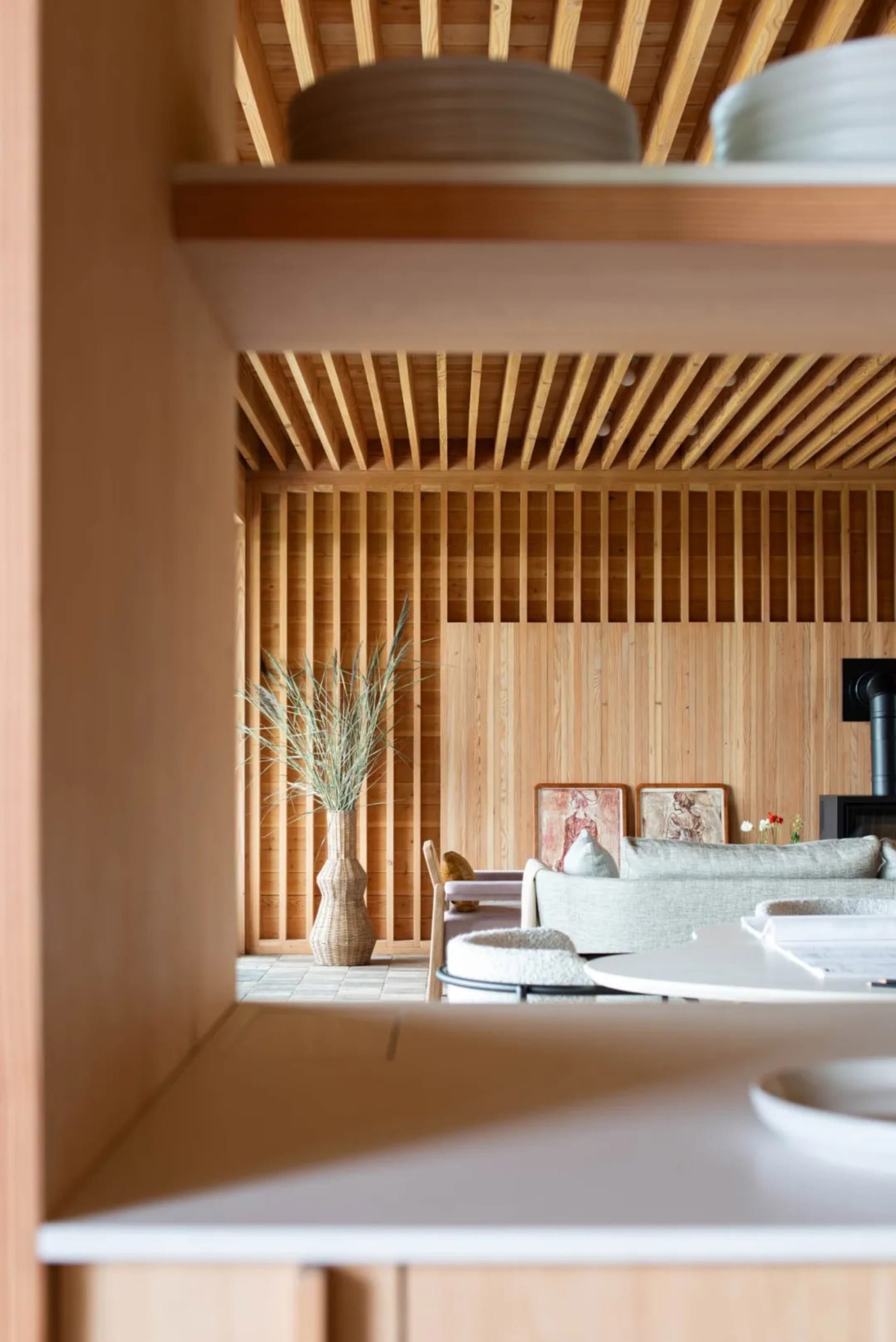 Warm and cozy living space with a large couch, wooden walls, and a fireplace, featuring comfortable seating and decorative elements