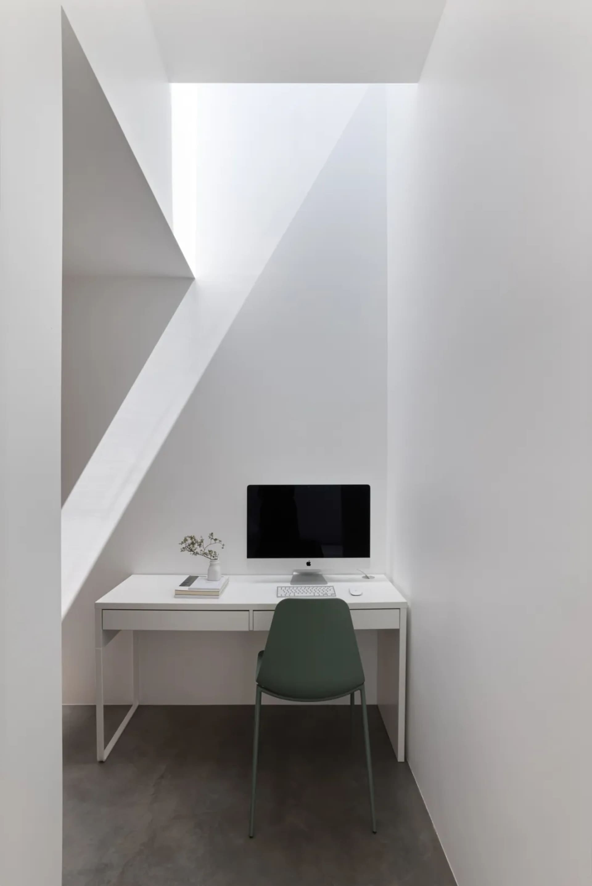 Office space with a desk, chairs, and natural light from a window