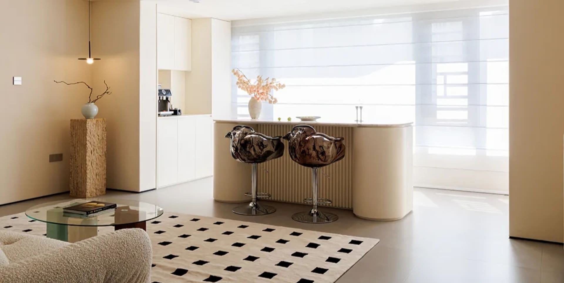 Inviting kitchen with white cabinets, black countertop, and a cozy seating area with stools at a countertop island