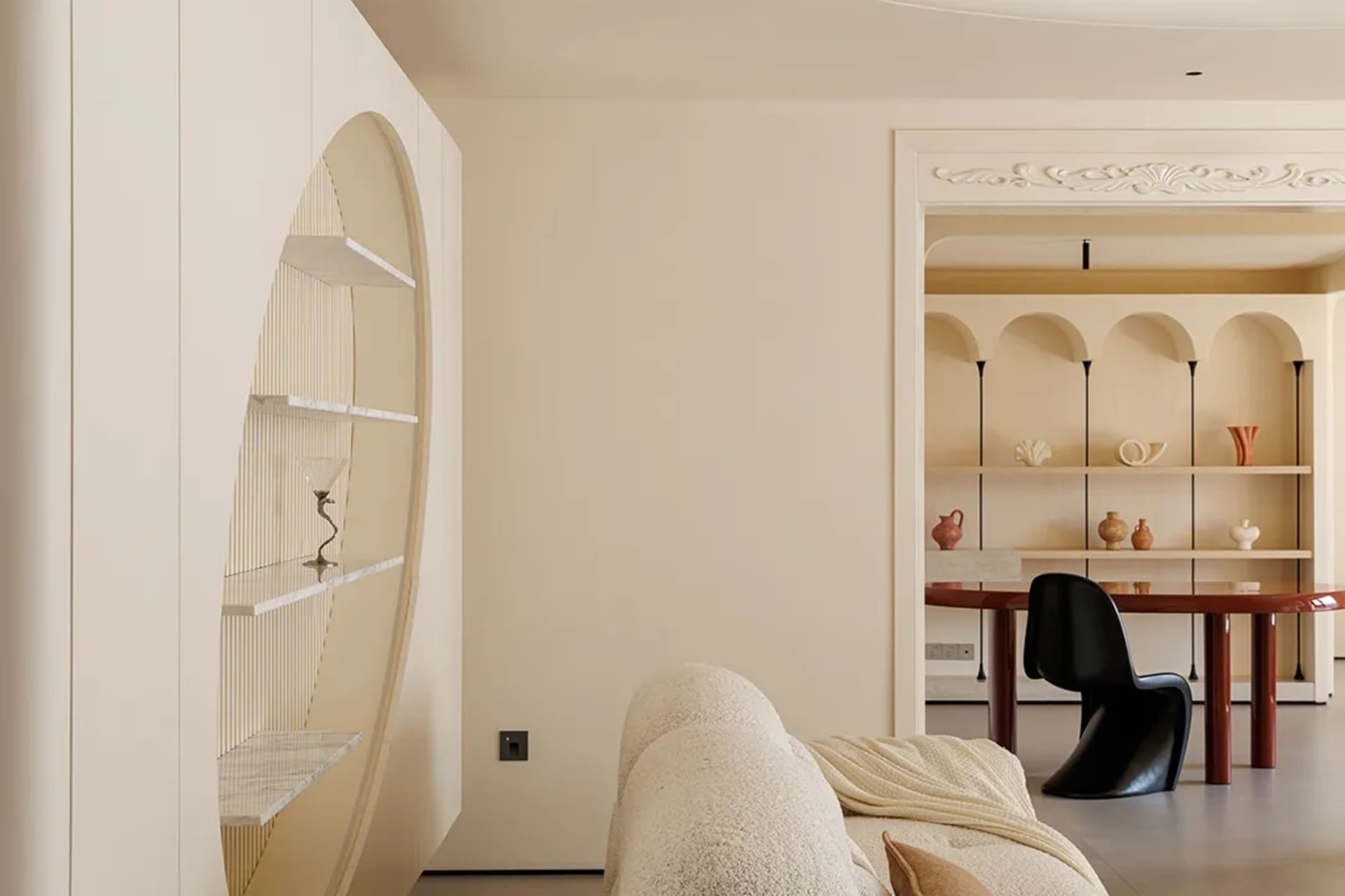 A modern living space with a couch, chair, and dining table, featuring white walls and minimal decoration, creating a comfortable and inviting atmosphere