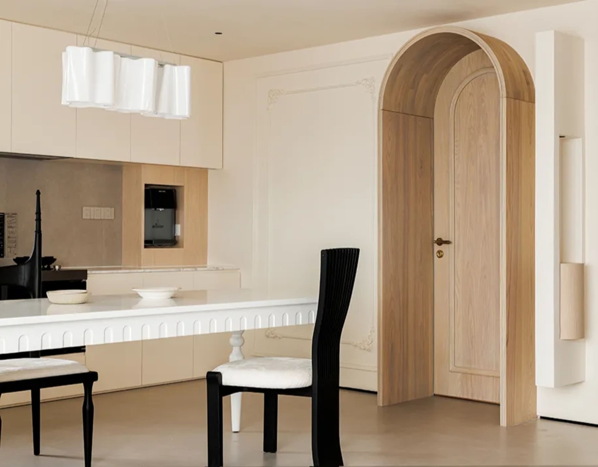 Modern kitchen with white walls, wooden floors, a dining table, chairs, and a microwave, featuring a clean and elegant design