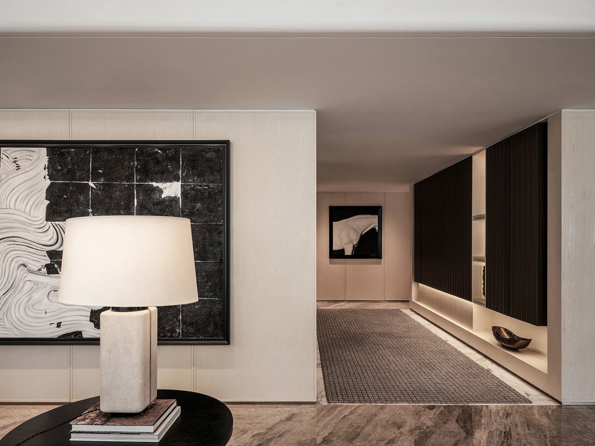 Empty modern hallway with white walls and flooring, featuring two framed pictures and a central lamp