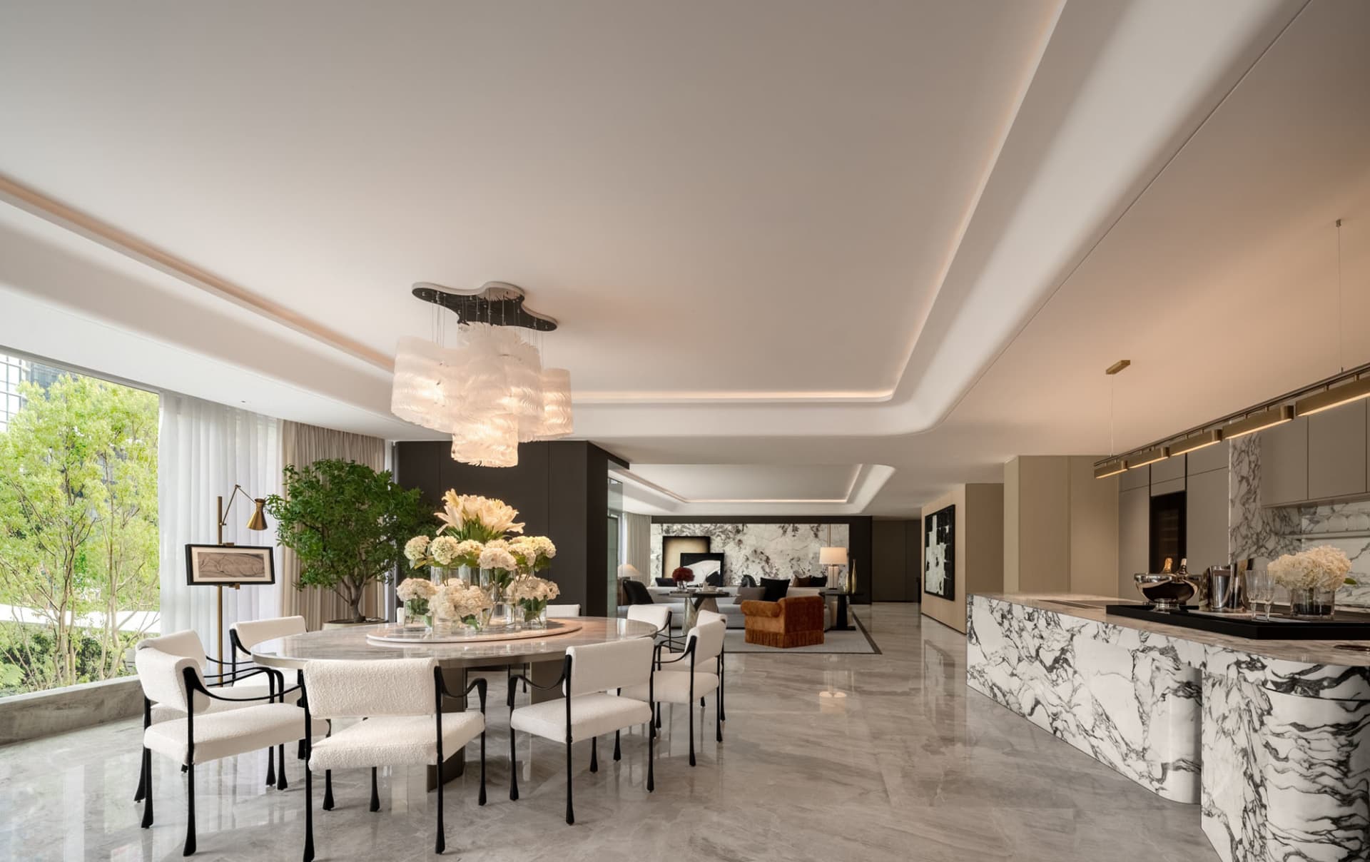 A luxurious dining room with a white table, surrounded by white chairs, and decorated with potted plants and flower vases
