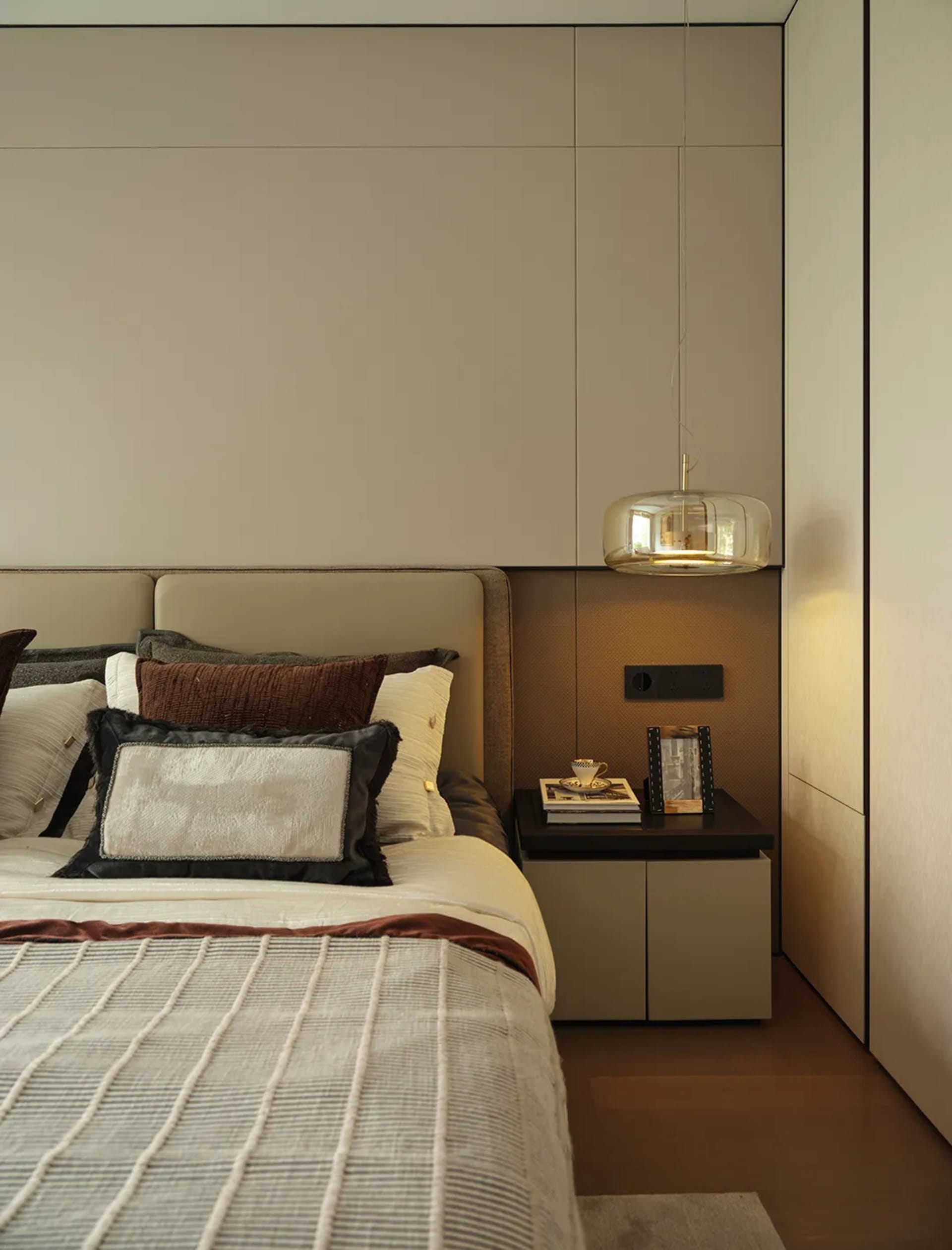 Cozy bedroom with a large bed, white bedding, and two lamps, set against a gray wall with brown accents