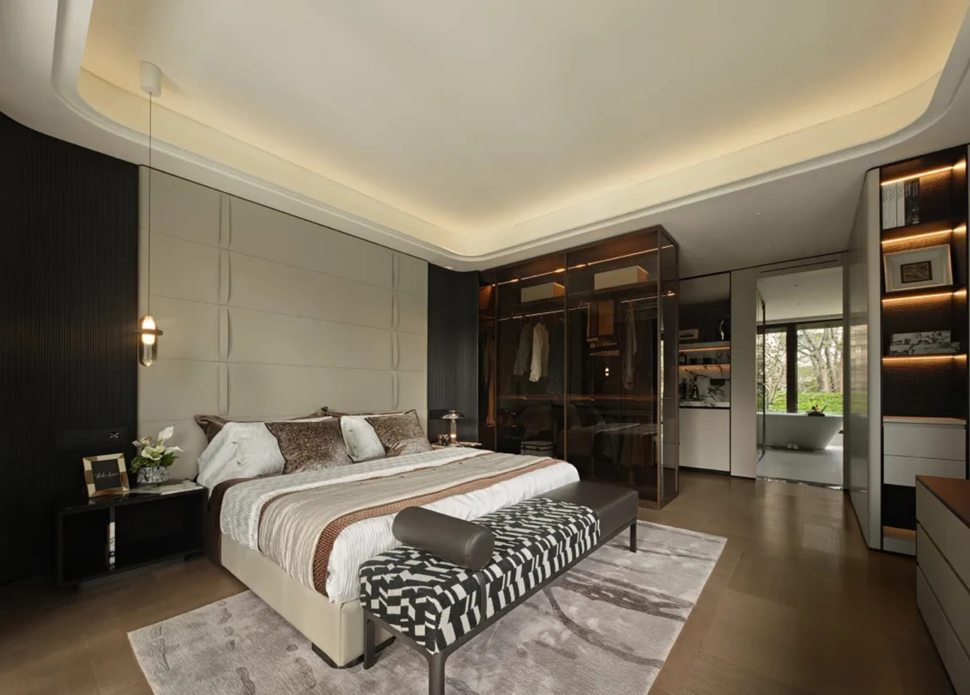 Spacious bedroom with a brown and white comforter, two couches, chairs, a dresser, and a dining table, creating a cozy and inviting atmosphere with neutral tones and earthy hues