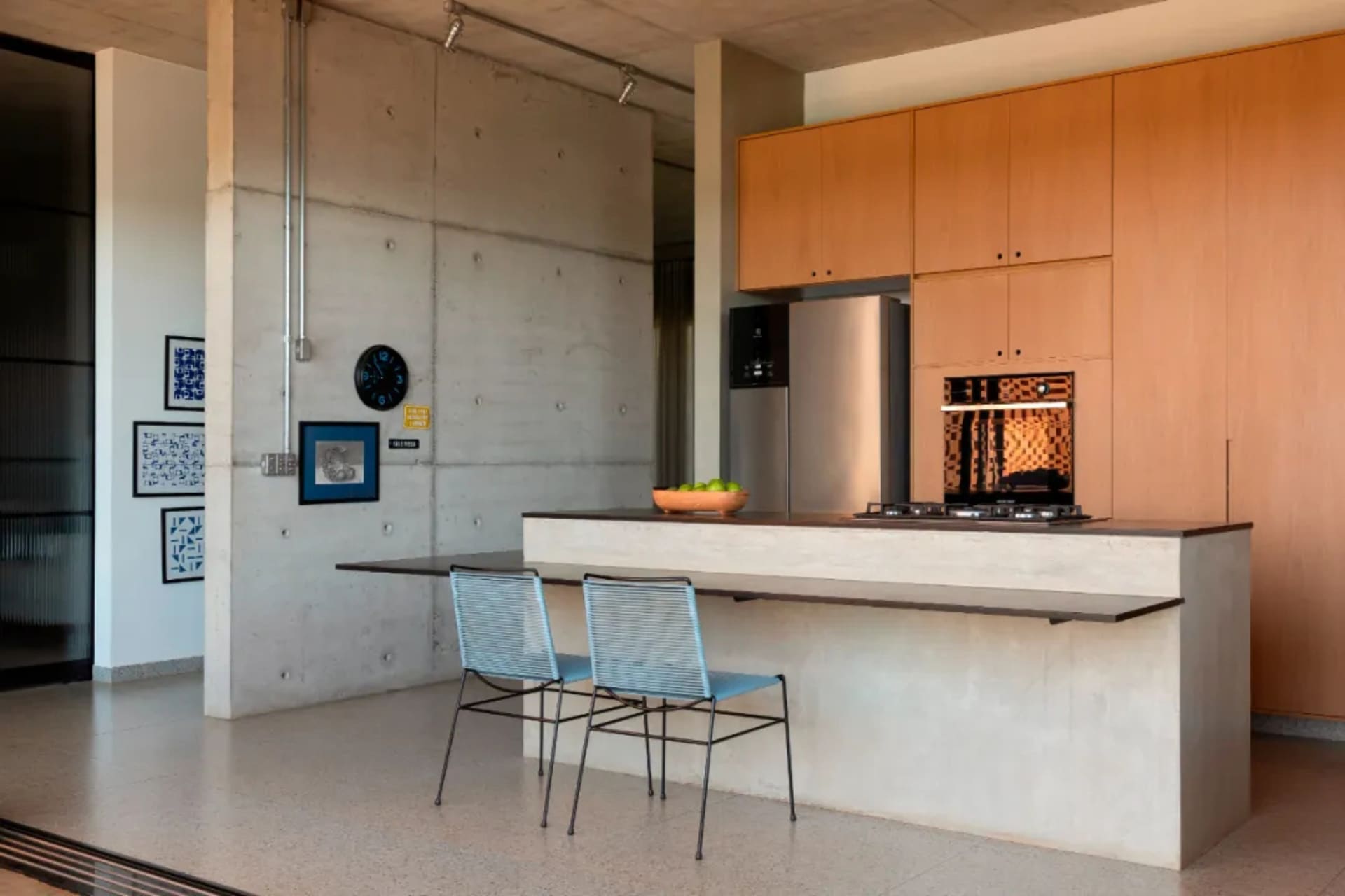 Bright modern kitchen with a countertop island, white cabinets, stainless steel appliances, and a clock on the wall