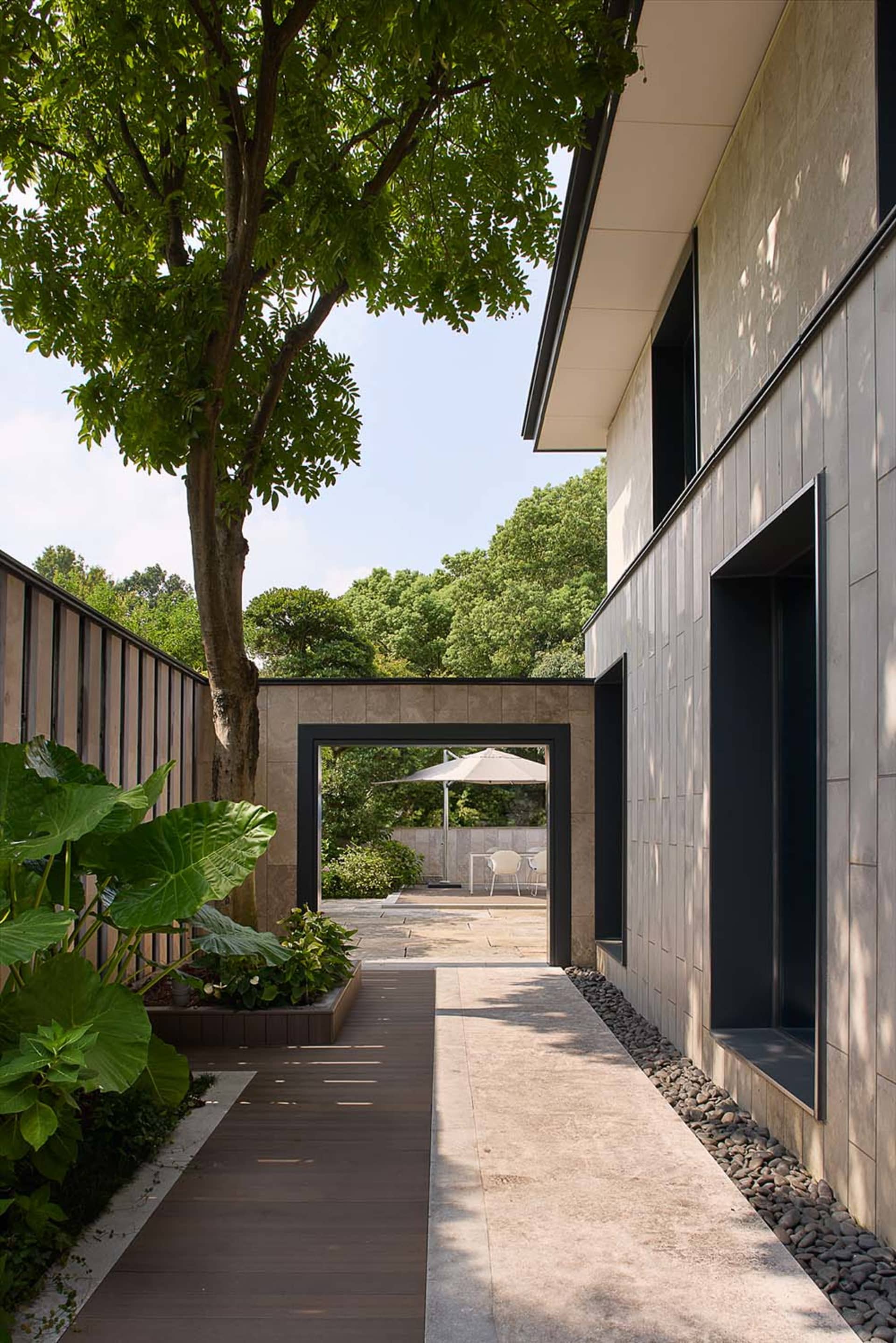 A traditional house with a stone exterior, featuring a patio area with chairs and a dining table
