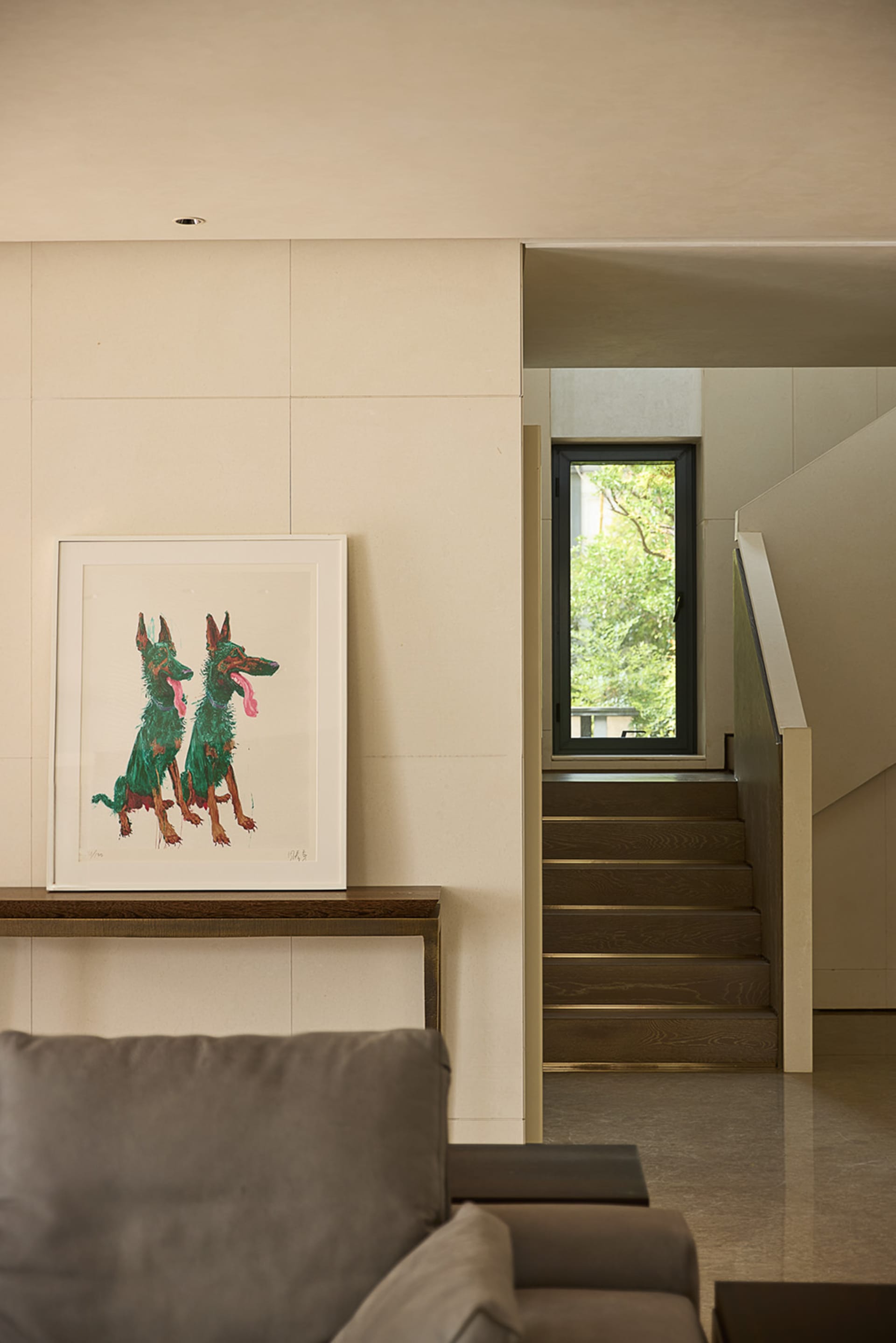 A warm and inviting living area with a wooden floor, featuring a painted dog mural and a framed dog painting, creating a cozy atmosphere