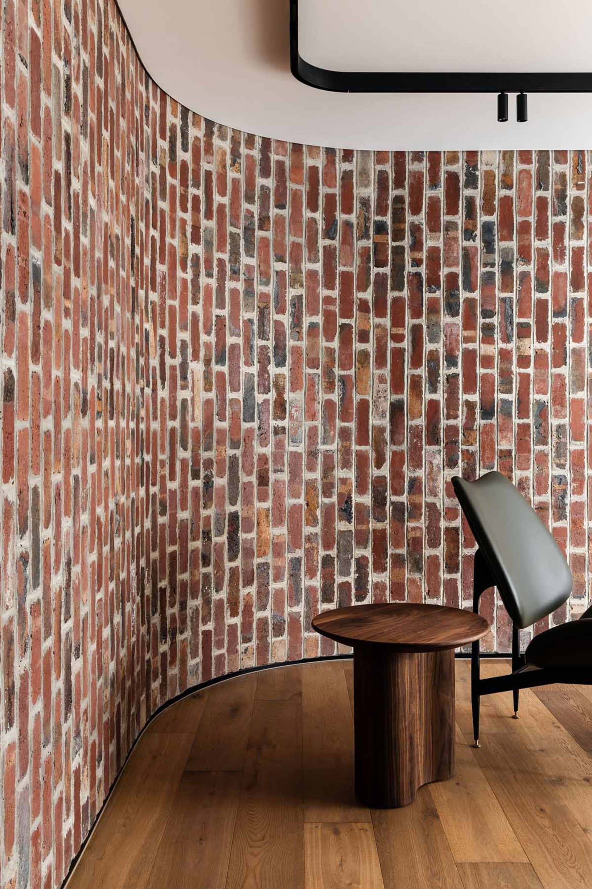 A cozy room with a brick wall, two chairs, and a dining table, creating a warm and inviting atmosphere