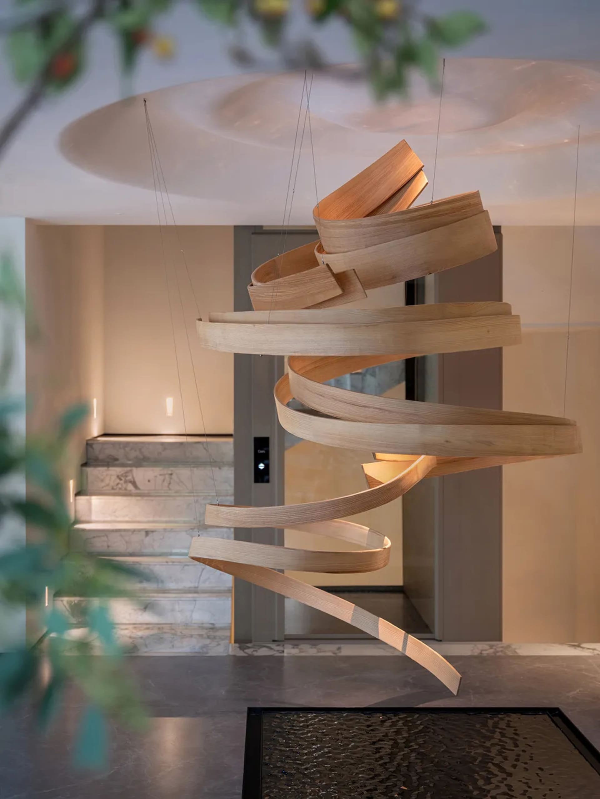A modern interior space with a spiral staircase made of wood, leading to another level, with an elegant and sophisticated atmosphere