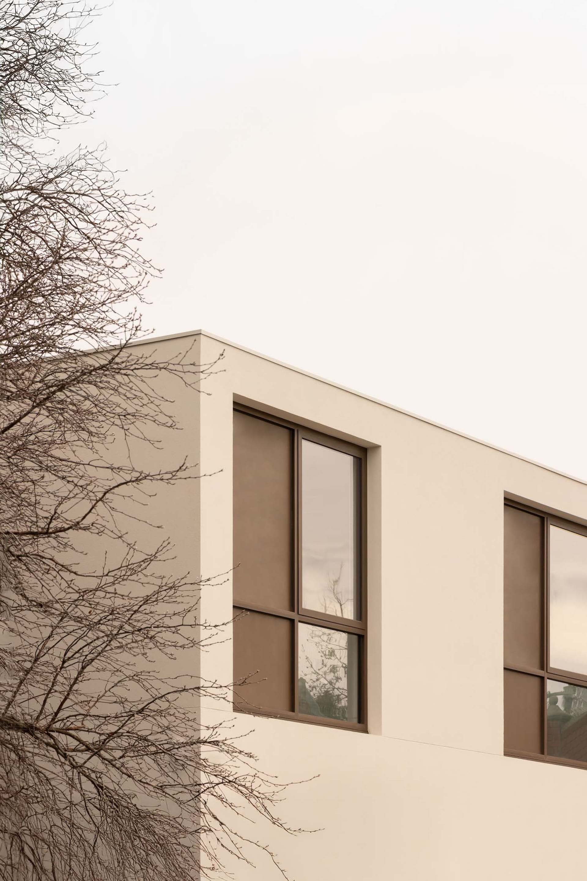A white building with large windows on its side, surrounded by natural light, giving a sense of openness and brightness
