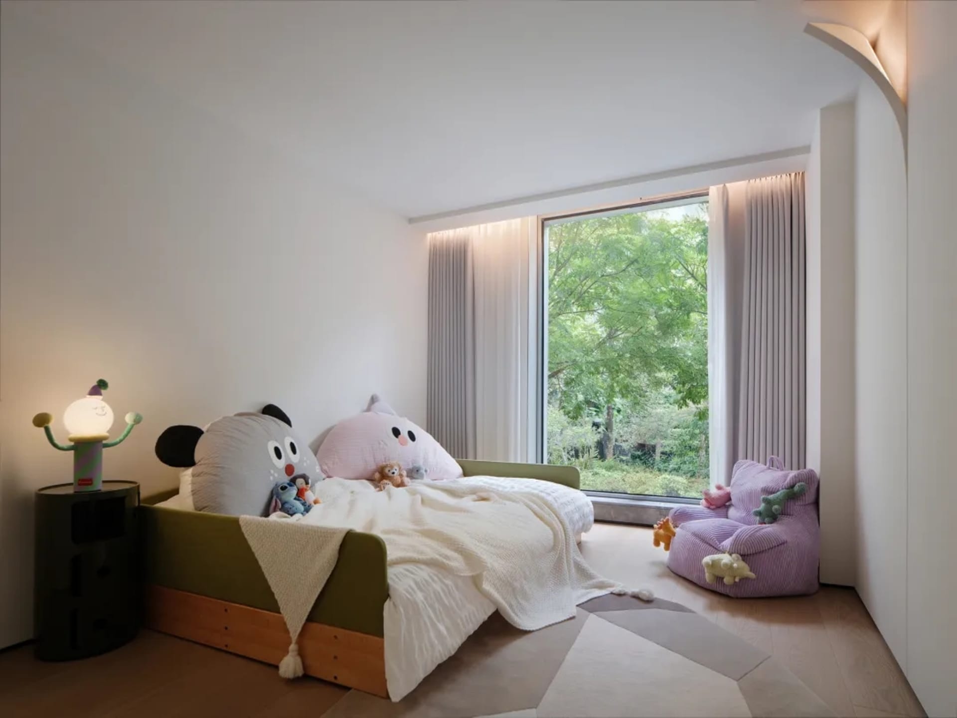 A warm and inviting bedroom with a large bed, a chair, and stuffed animals, set against a neutral background