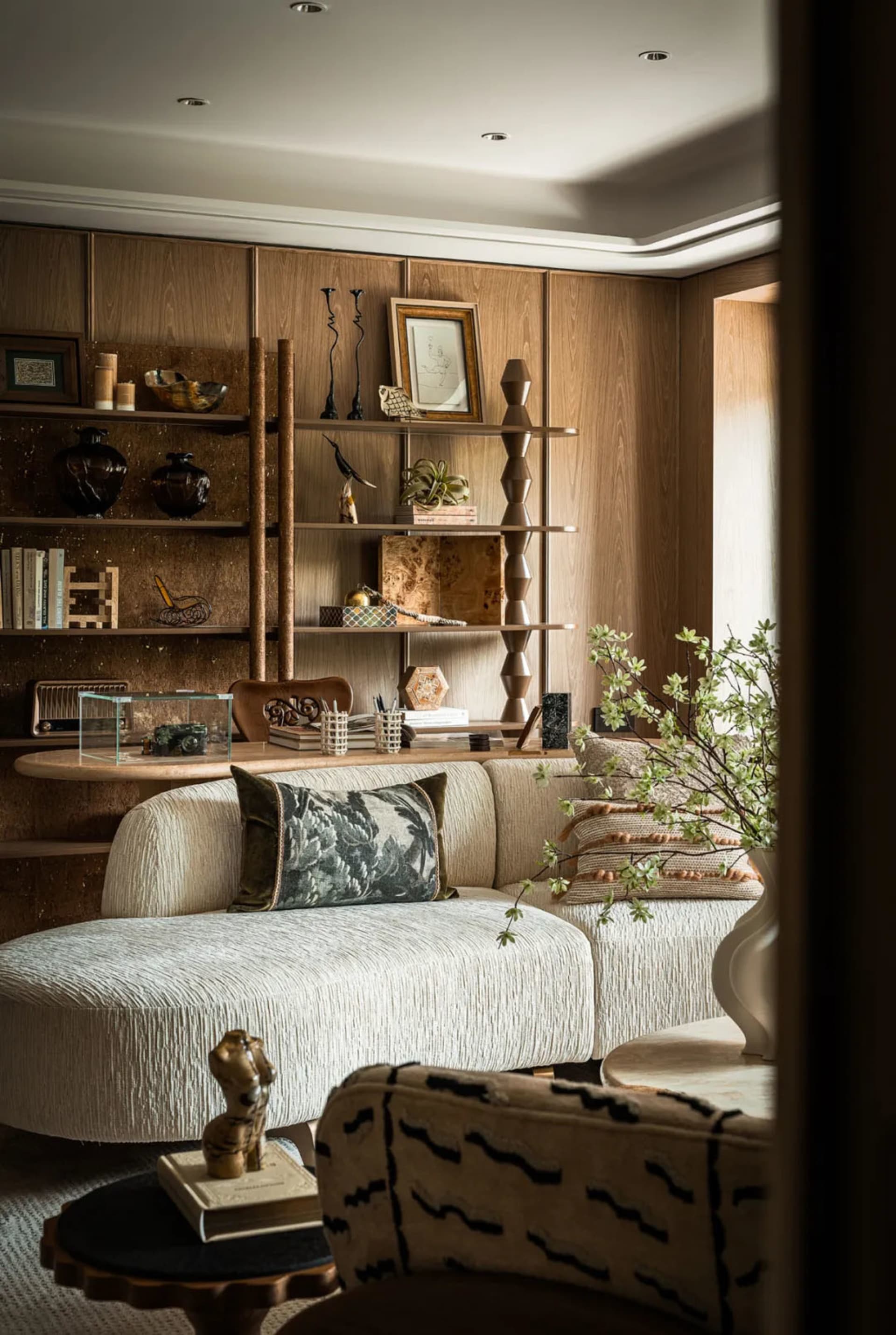 Cozy living space with a couch in front of a bookshelf, vases, and decorative elements