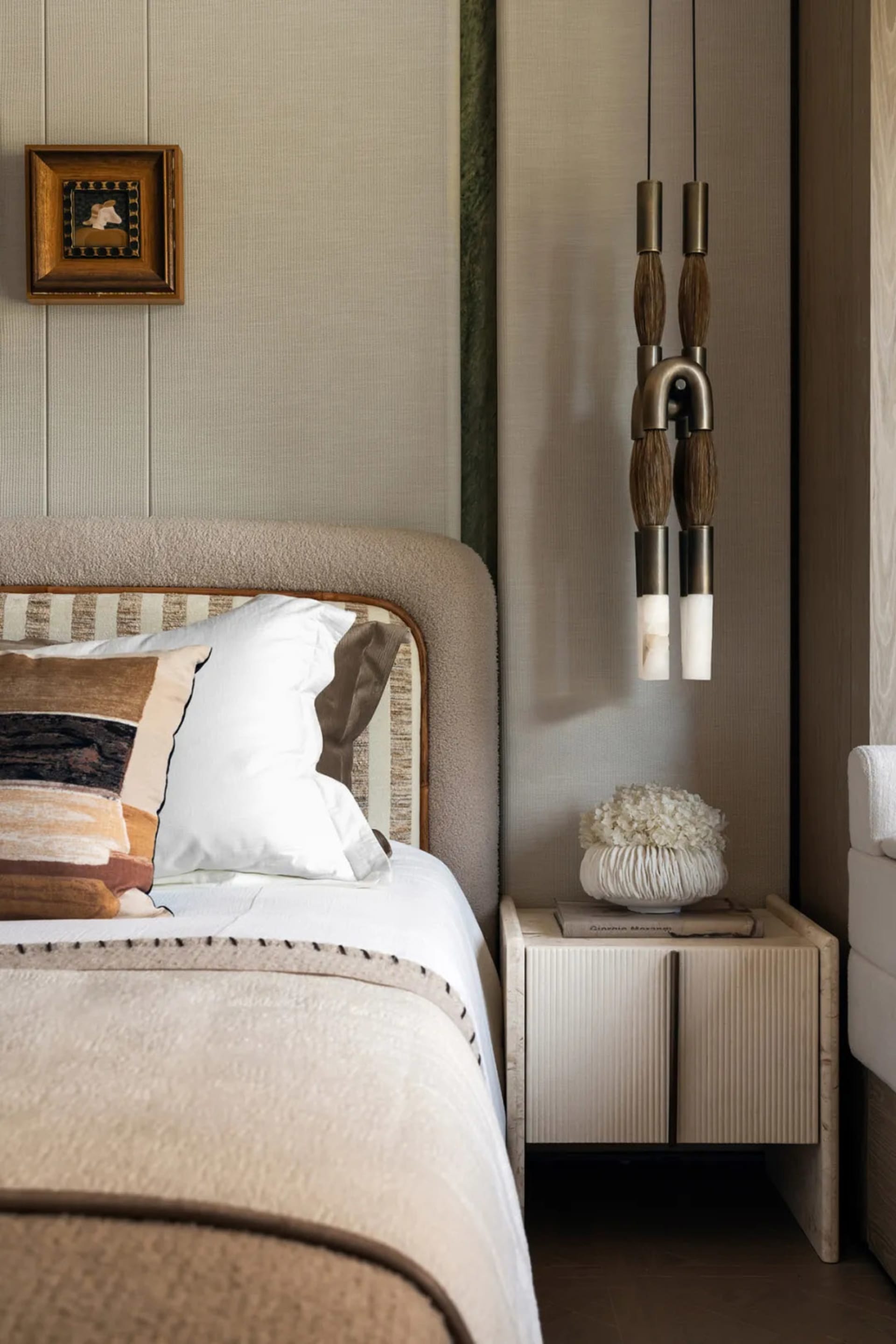 A cozy hotel bedroom with a large bed, white bedding, and wooden paneling on the walls