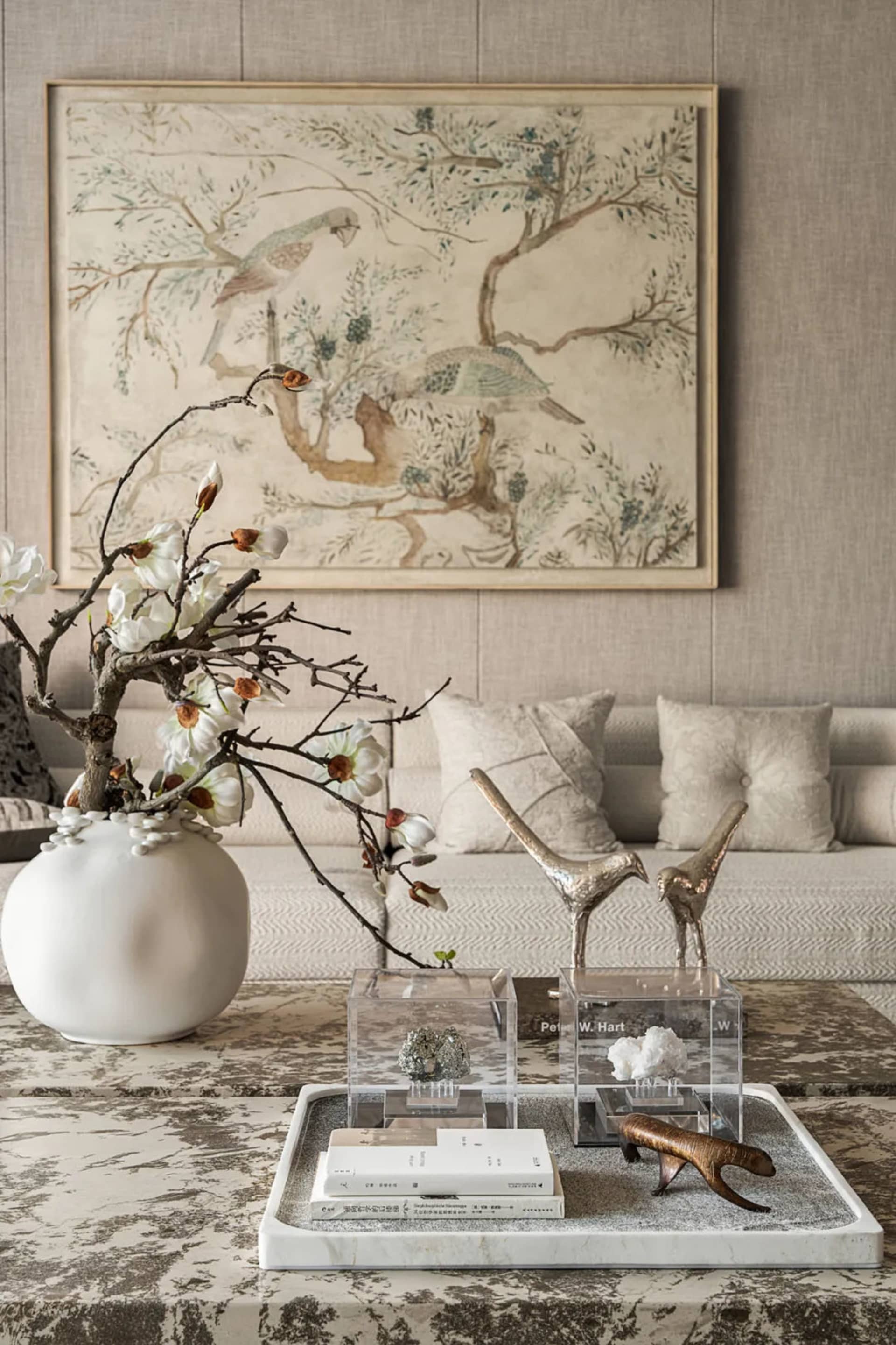 Elegant living room with furniture, decorative items, vases, potted plants, chairs, dining table, and a bird statue, featuring wood accents and natural elements