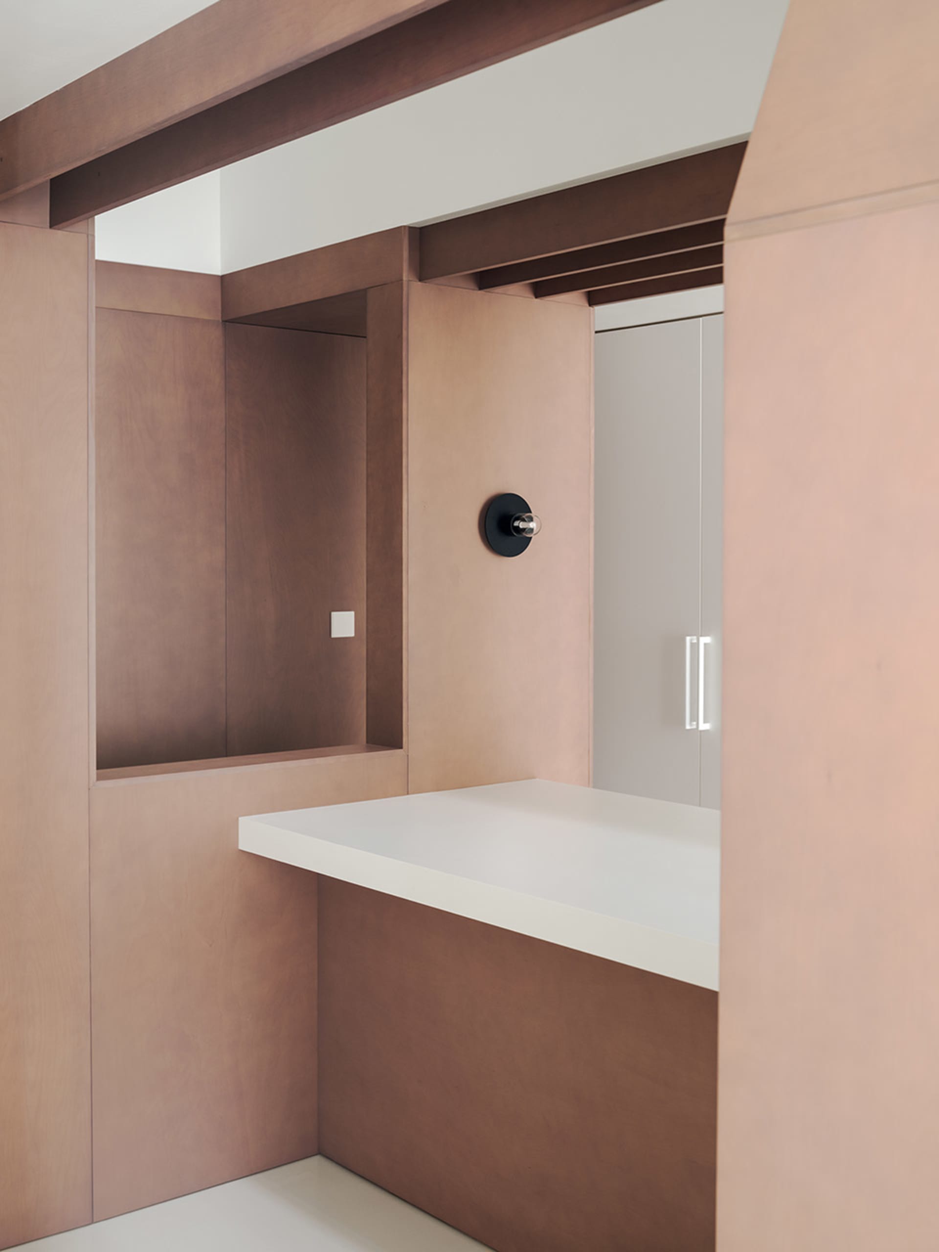 A kitchen with a wooden countertop, a mounted clock, and a warm atmosphere