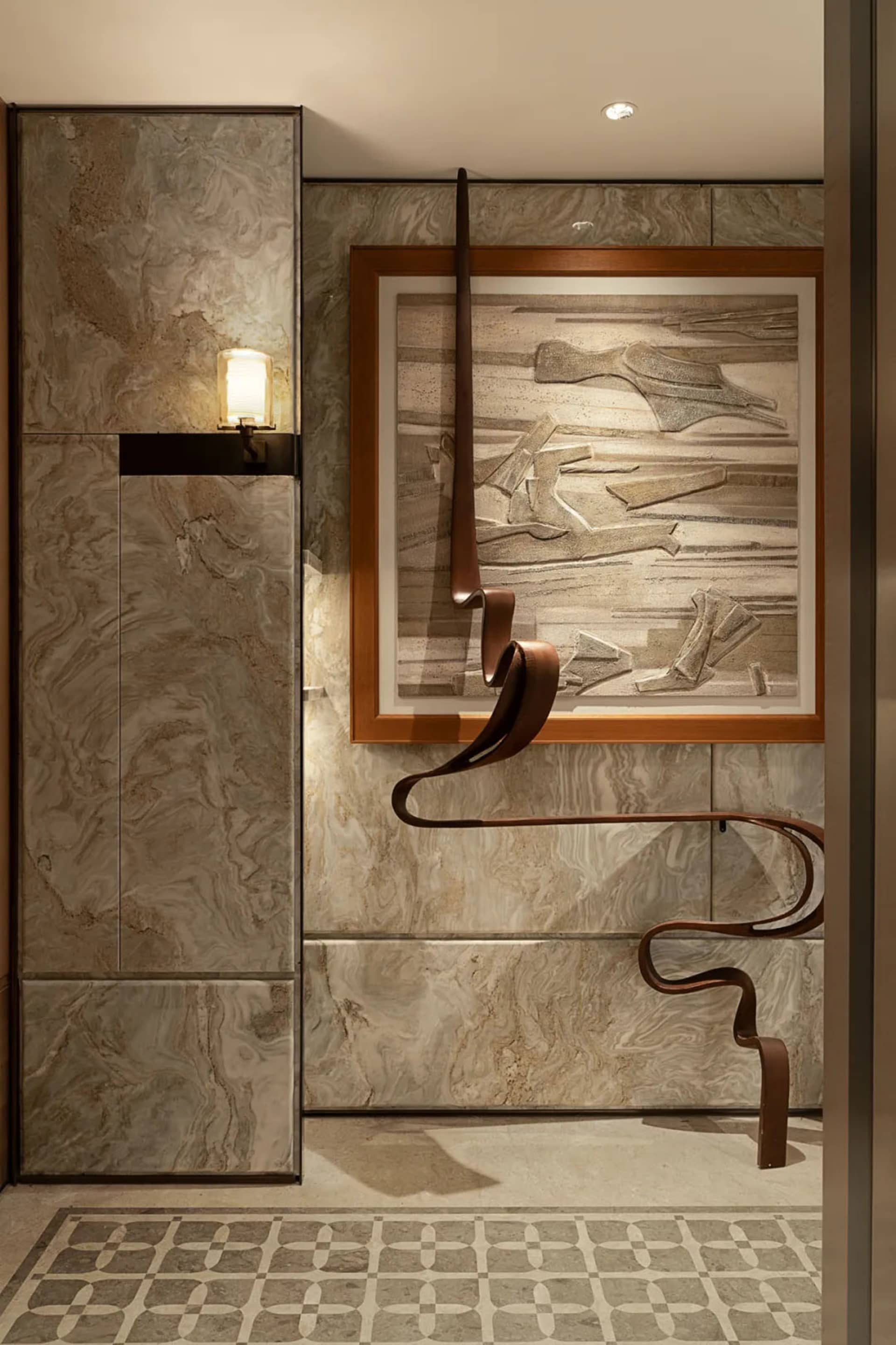 Cozy bathroom with a brown tile wall, a picture hanging on it, and two lights, creating a warm and inviting atmosphere