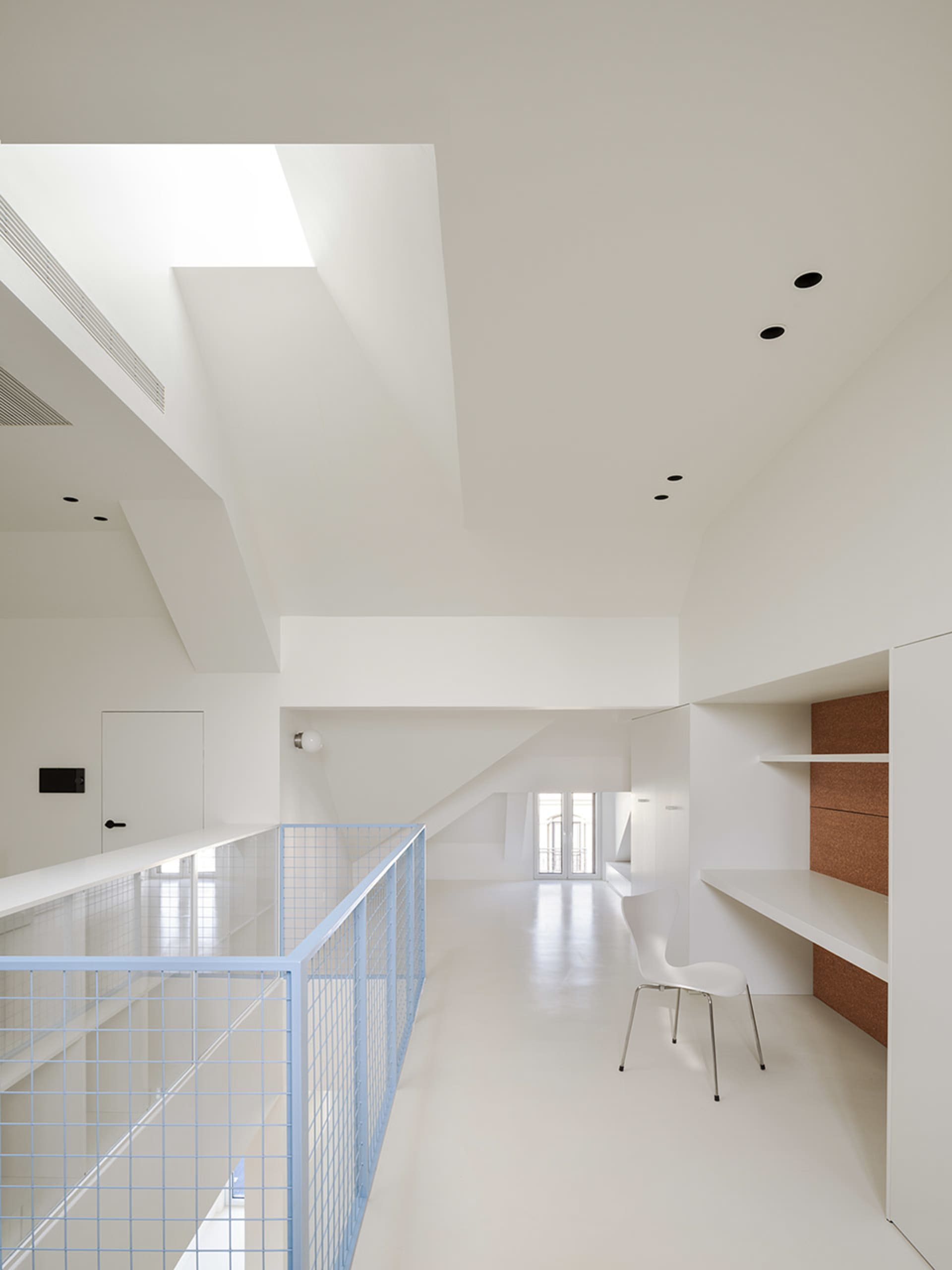Modern open space with a staircase, two chairs, and concrete walls