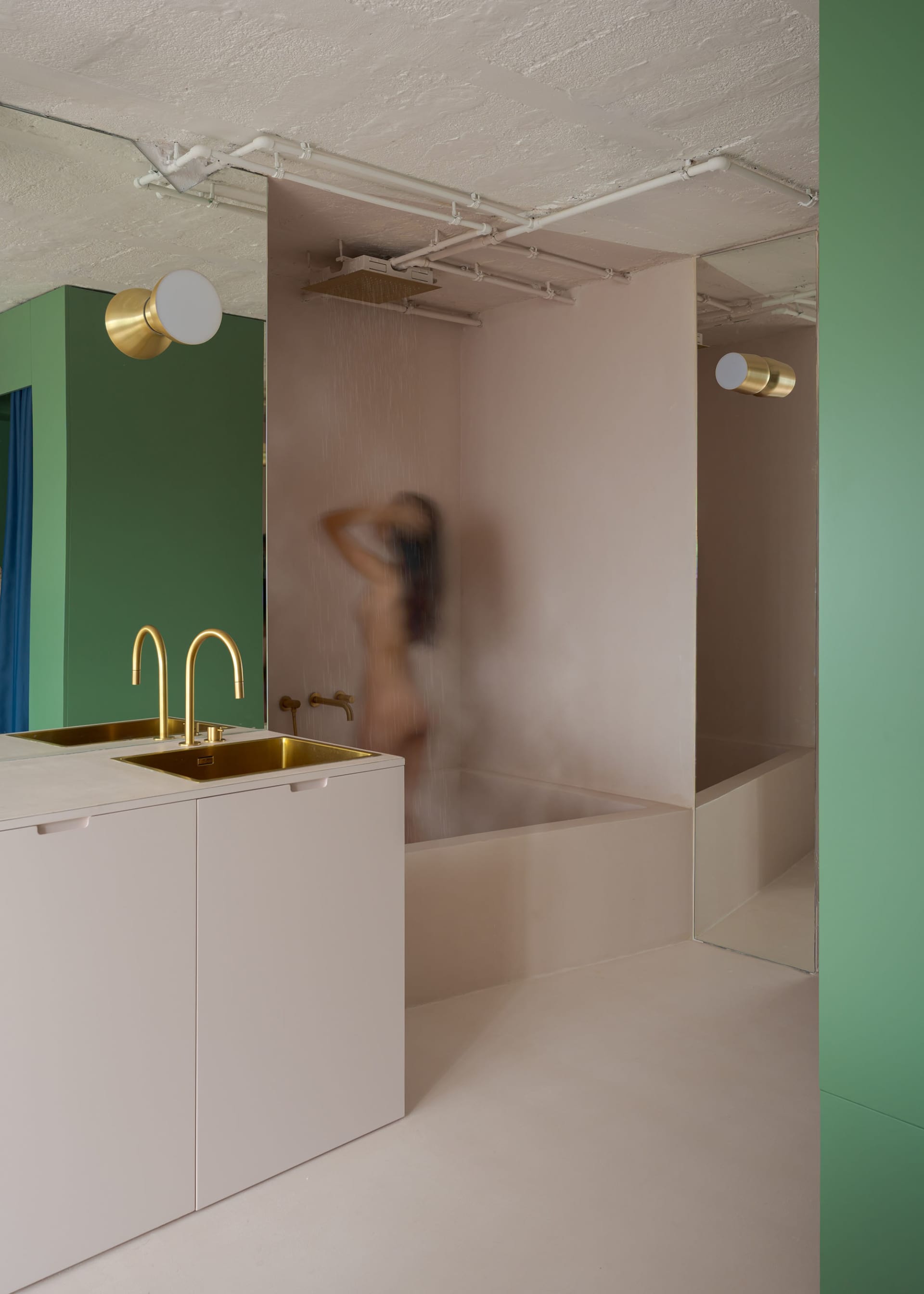 A woman takes a shower in a private bathroom with a sink and mirror, surrounded by a sense of intimacy