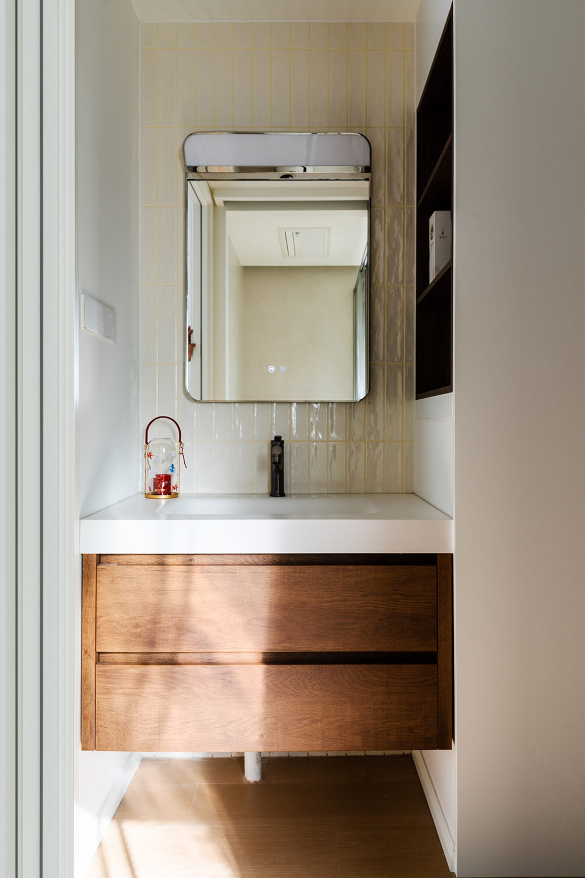 Modern bathroom with a sink area, mirror, and two bottles on the countertop