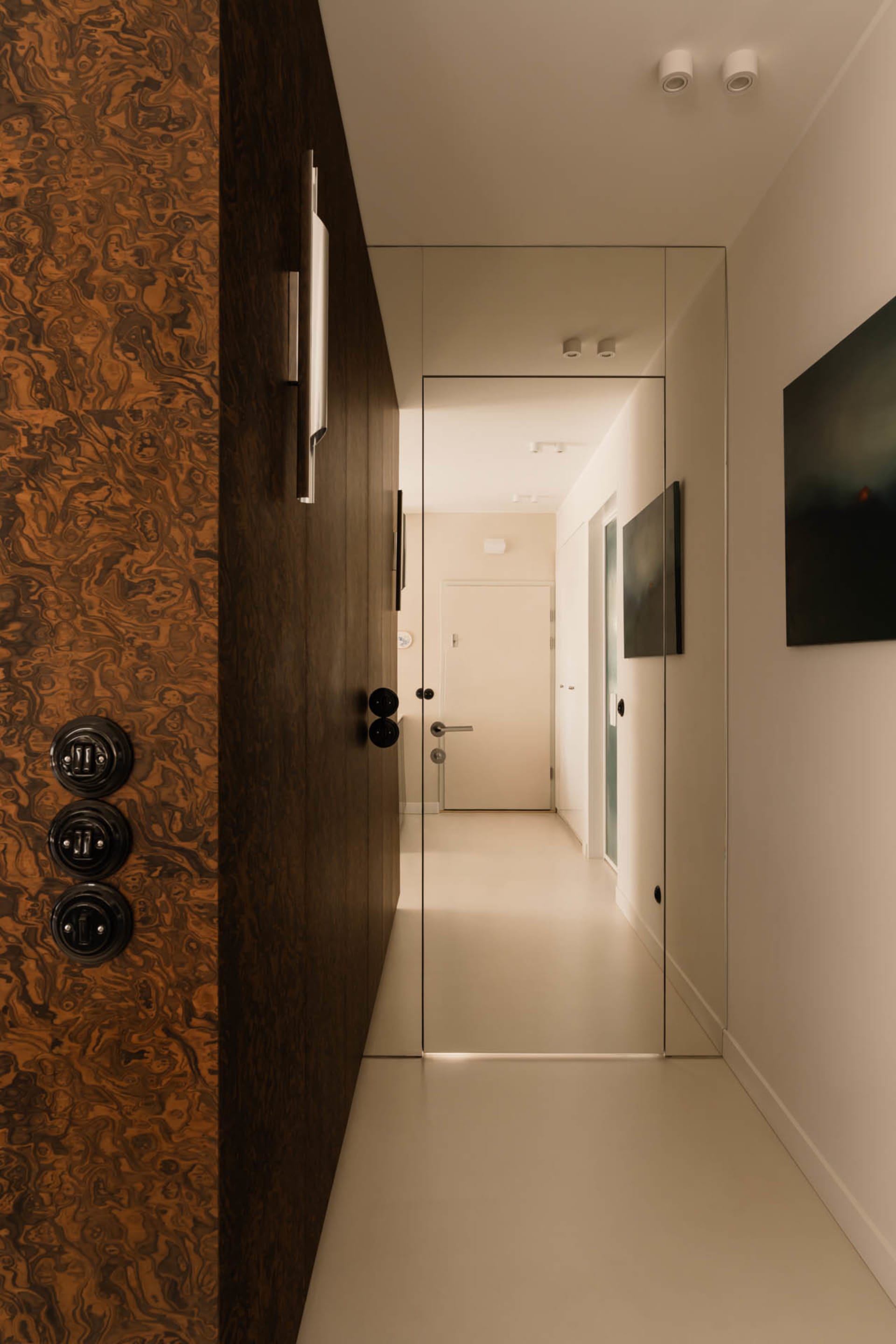 Narrow hallway with a white wall and two wooden door frames, creating a cozy and traditional atmosphere
