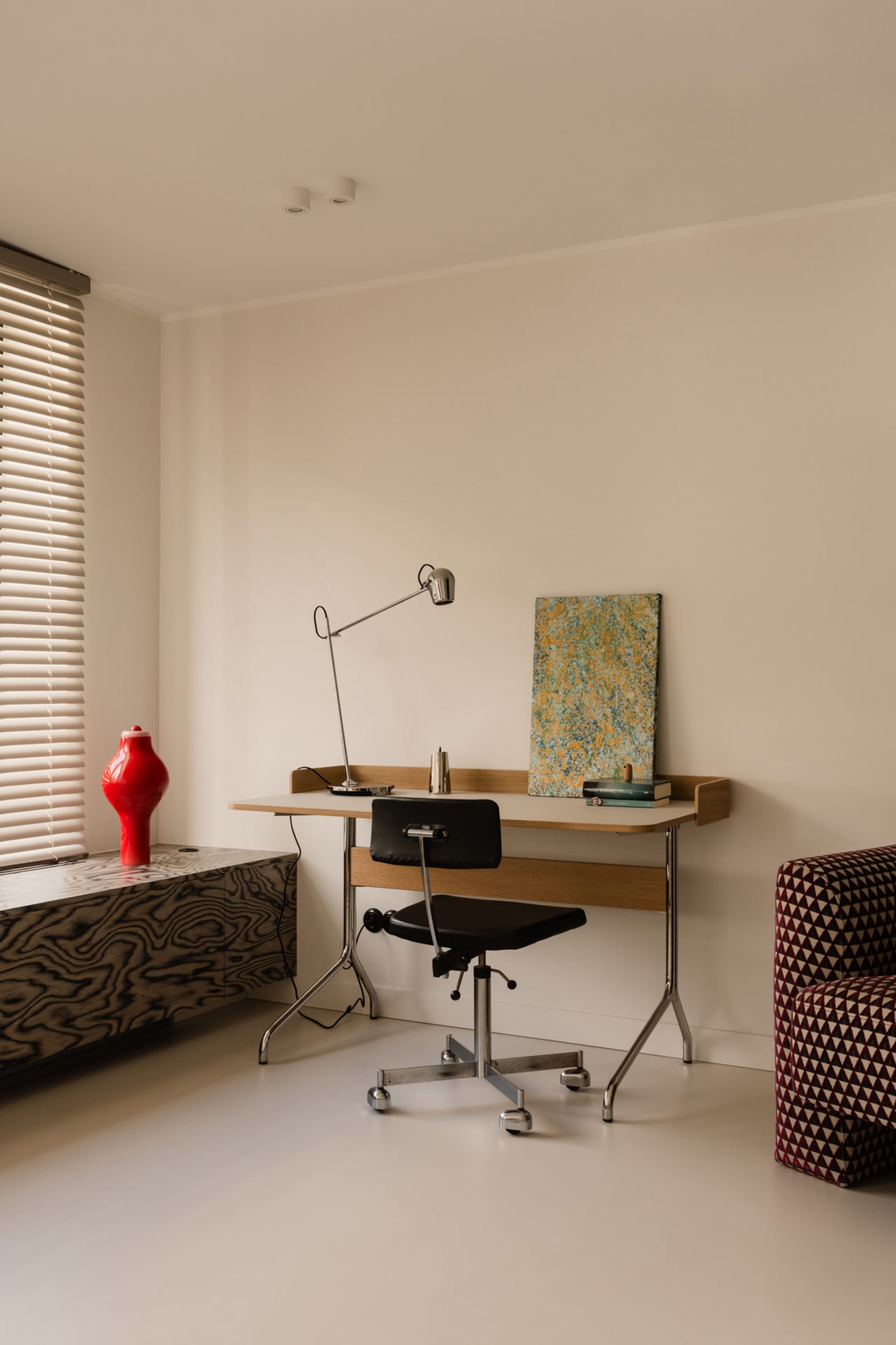 A well-organized office space with a desk and two chairs, a vase on a nearby surface, and a calm atmosphere