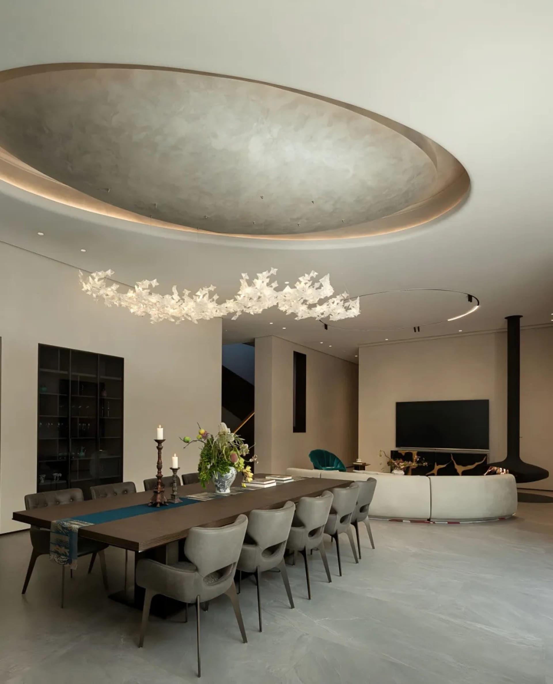 Bright and inviting living room with a modern design, white walls, gray ceiling, and potted plants surrounding a large dining table