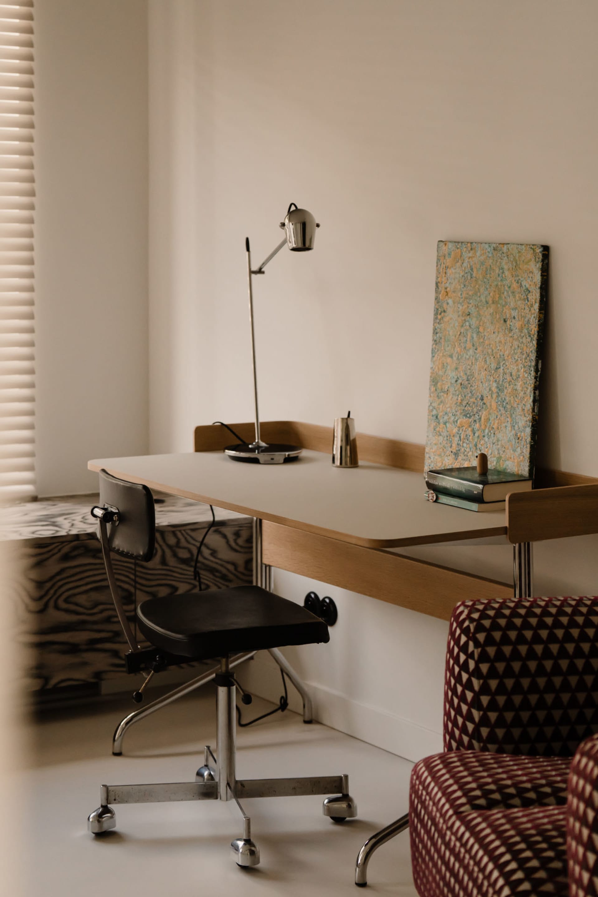Office space with a desk, two chairs, a lamp, and a book, creating a productive and organized atmosphere
