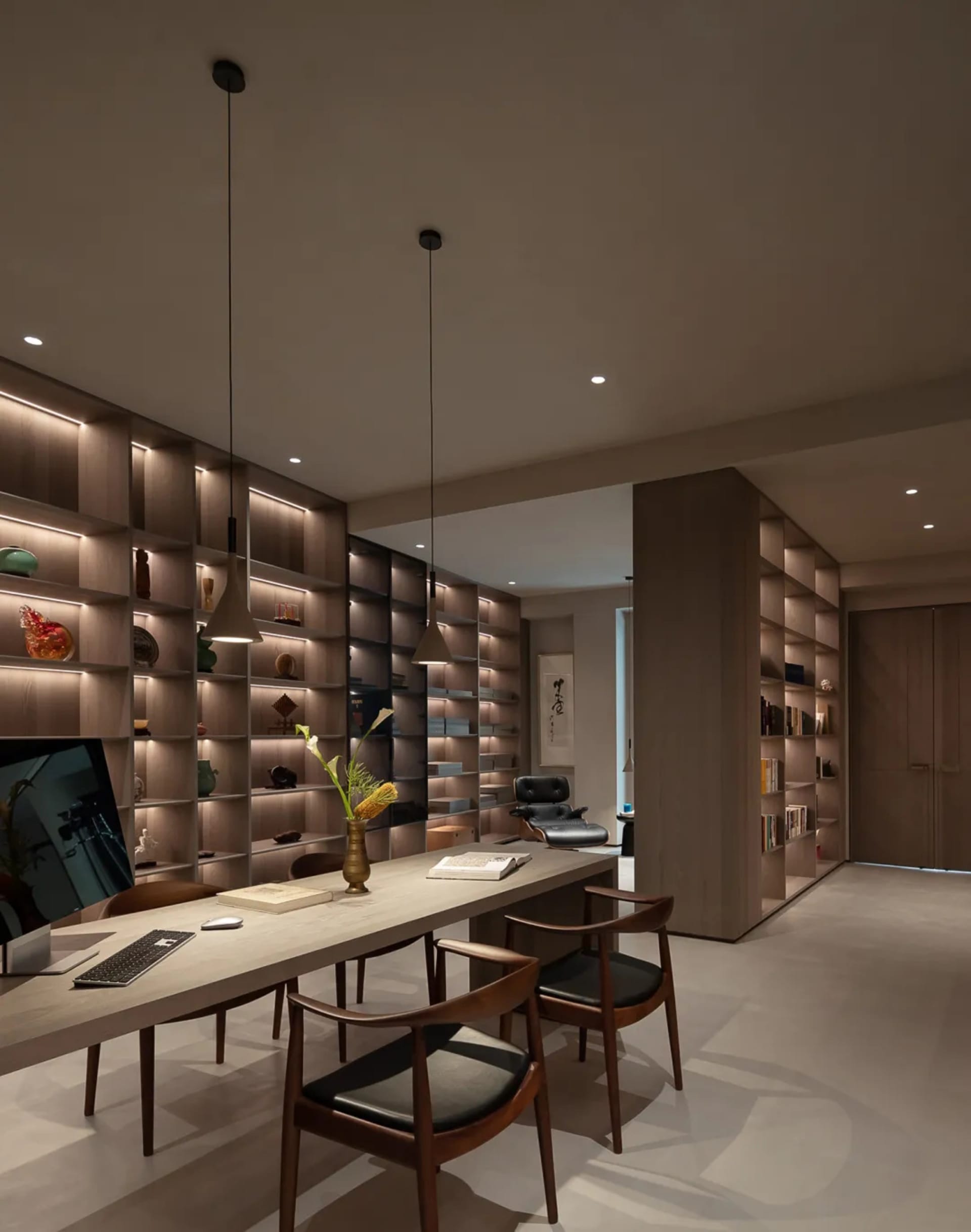 Cozy modern living space with a large bookshelf, chairs, a dining table, and a TV, featuring a comfortable and inviting atmosphere
