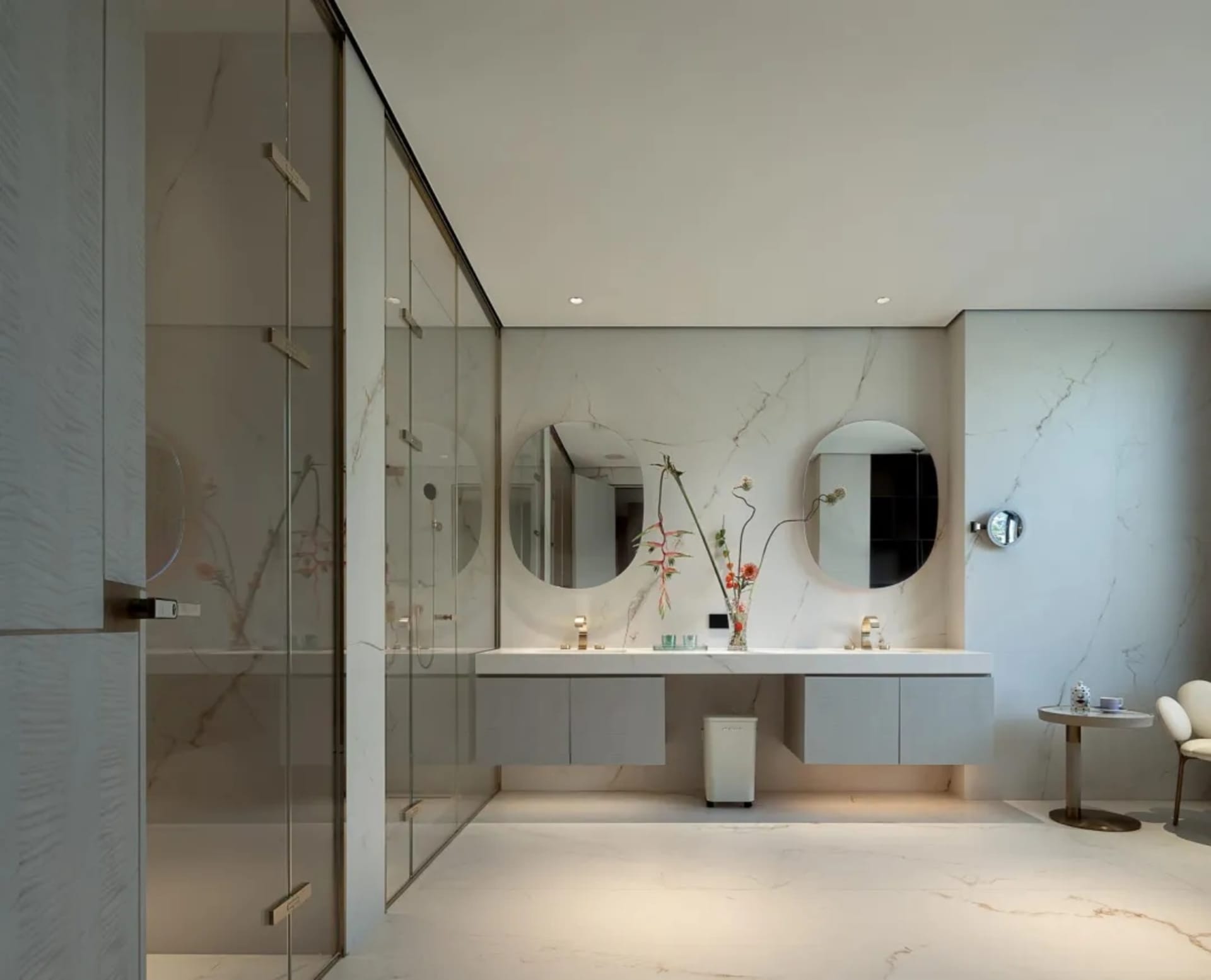 Modern bathroom with white walls, marble elements, and a large mirror above a sink, accompanied by a countertop and a cabinet, with two vases adding an elegant touch