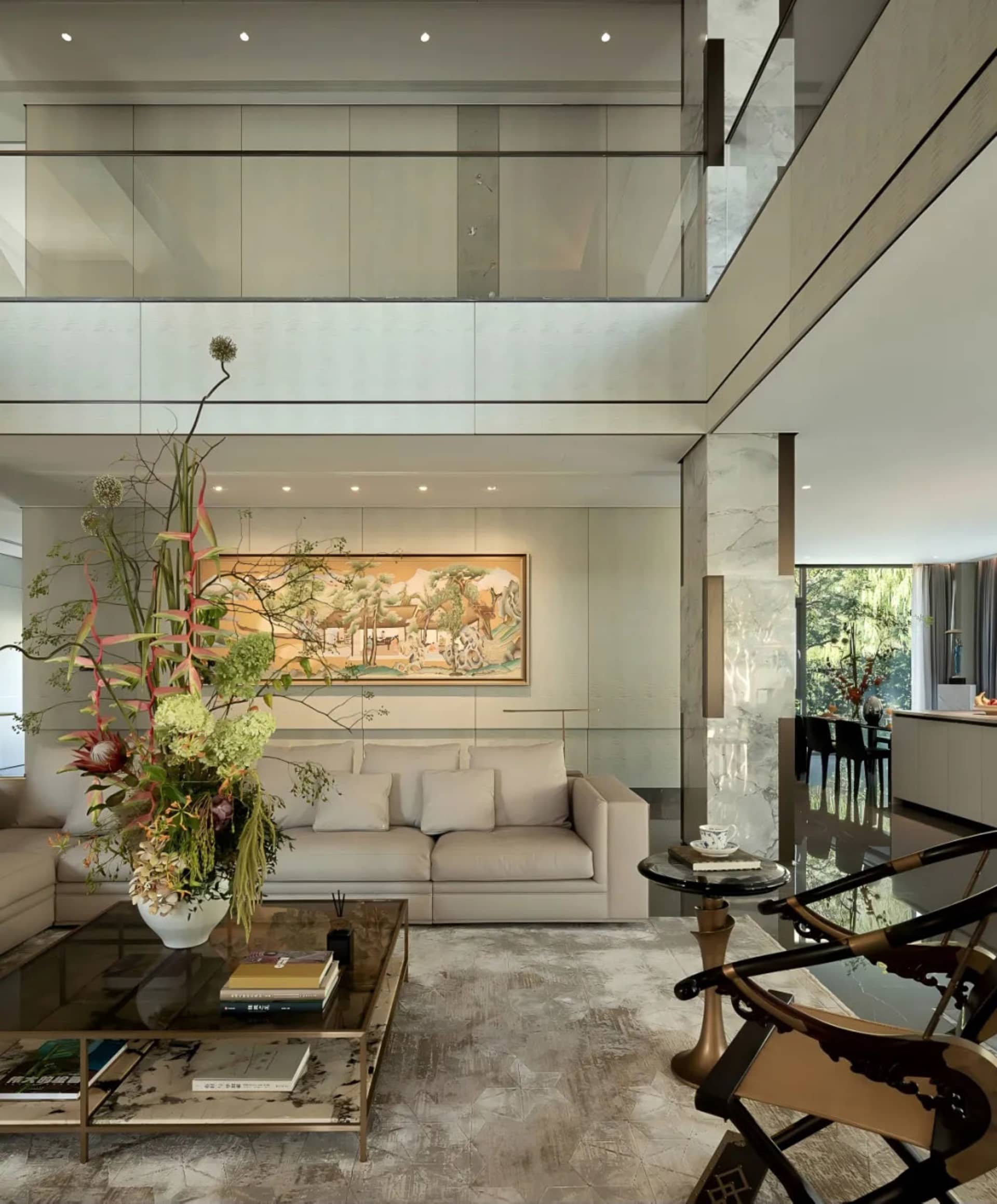 A modern living room with white walls and floors, featuring two couches, a chair, and a vase, with a well-lit and inviting atmosphere