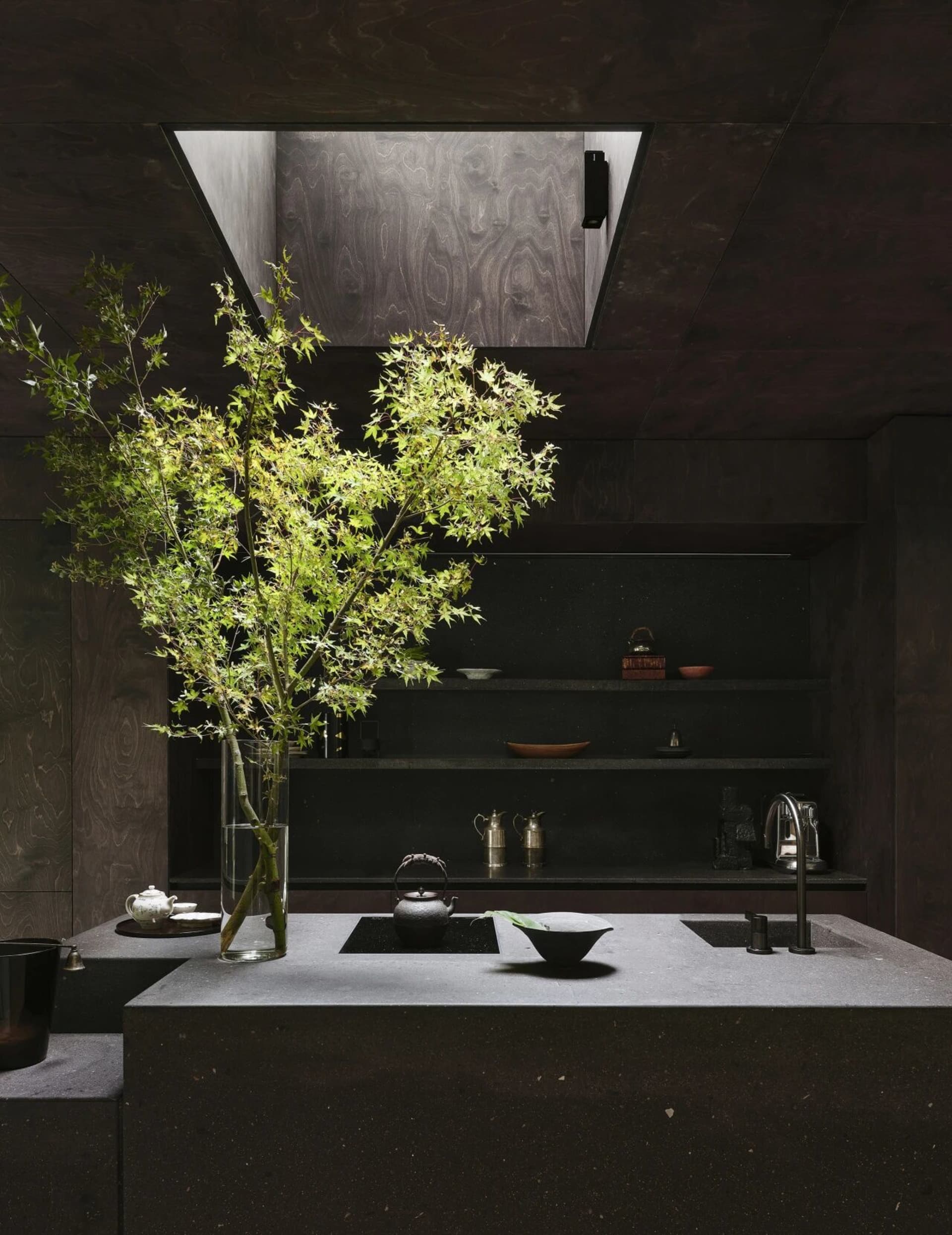 A kitchen scene with a sink, countertop, and various items arranged on the counter, creating a cozy and functional atmosphere