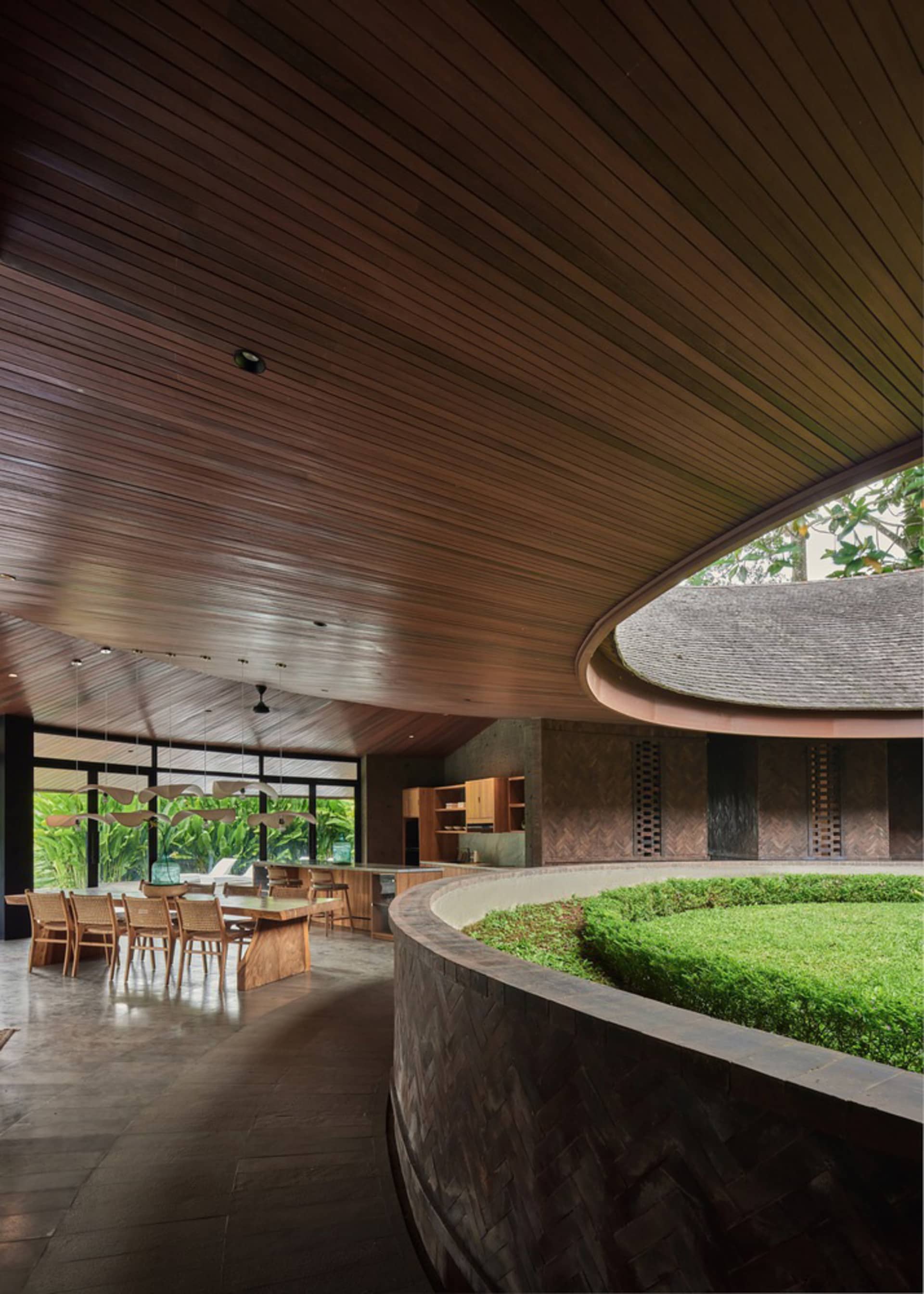 Dining room with a round table and chairs, surrounded by wooden walls and floors, creating a warm and inviting atmosphere