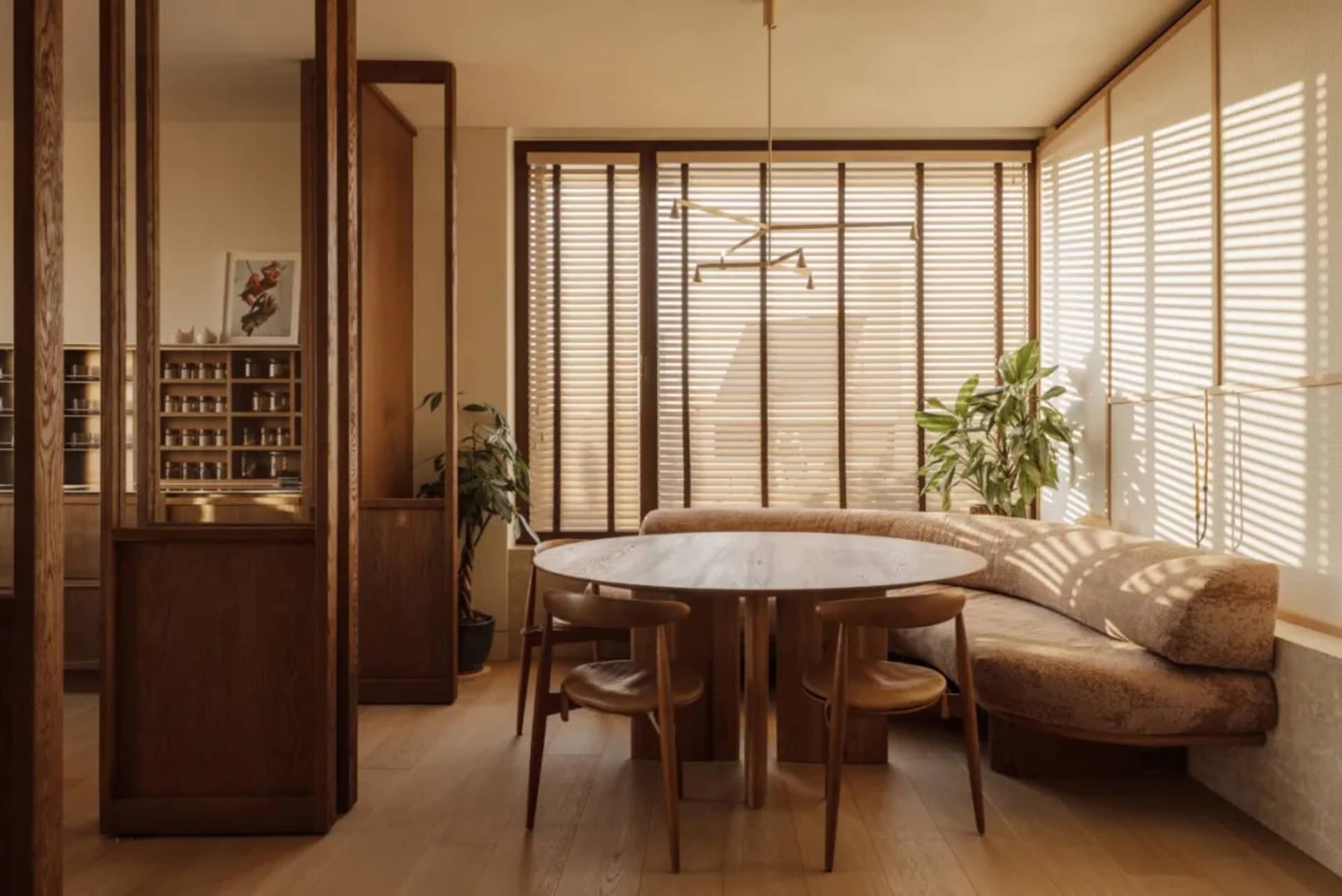 Open living area with a wooden dining table, wood paneling walls, and large windows for natural light