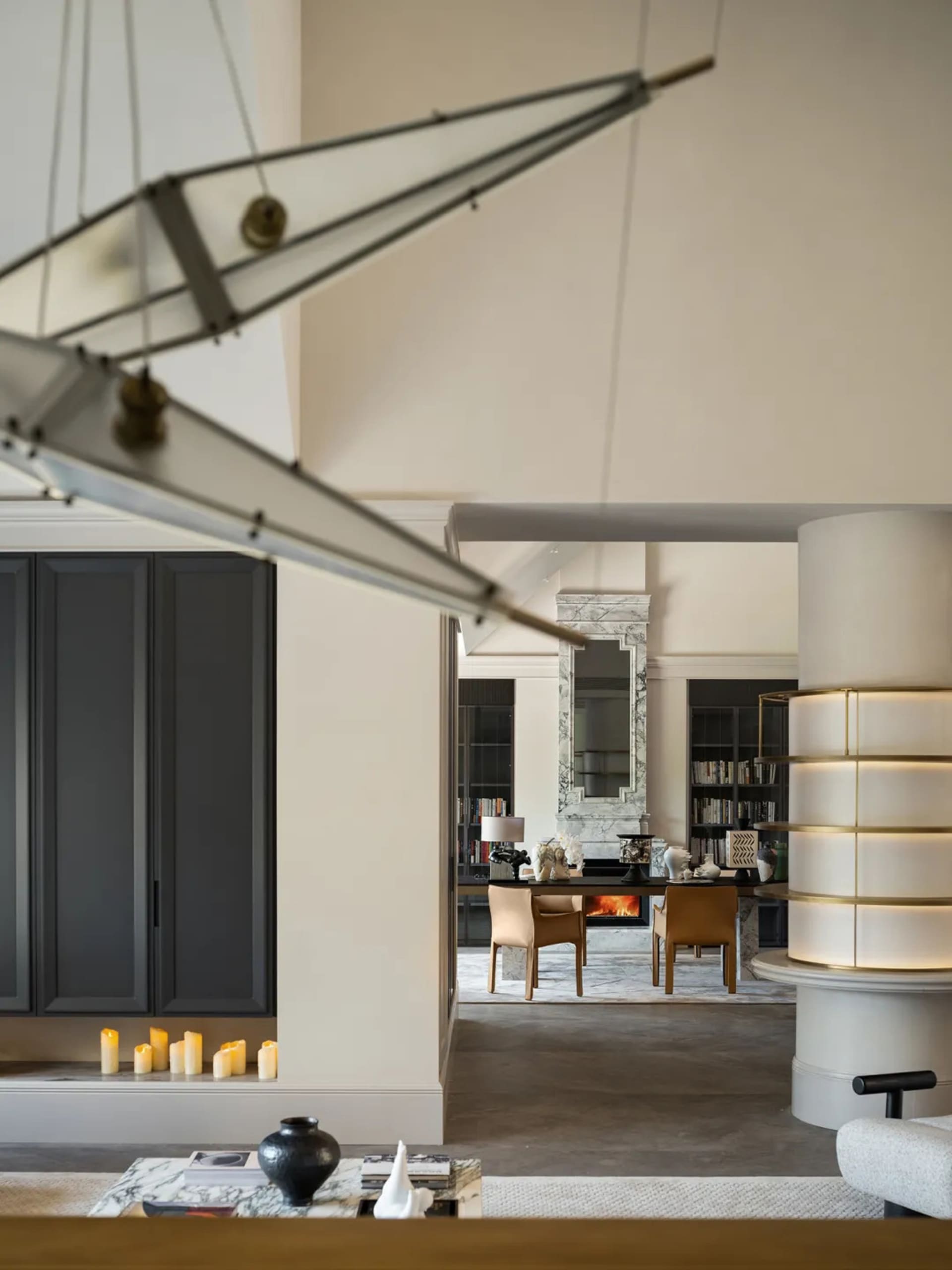 Cozy open concept living space with a dining table, chairs, and scattered books, featuring a warm and inviting atmosphere