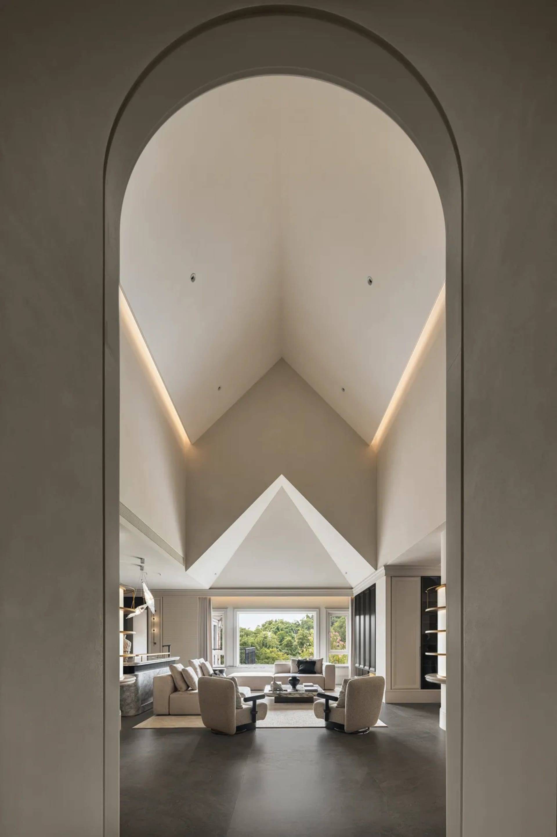 開放式客廳與餐廳區，挑高天花板，兩組沙發、一張單椅，以及餐桌椅組