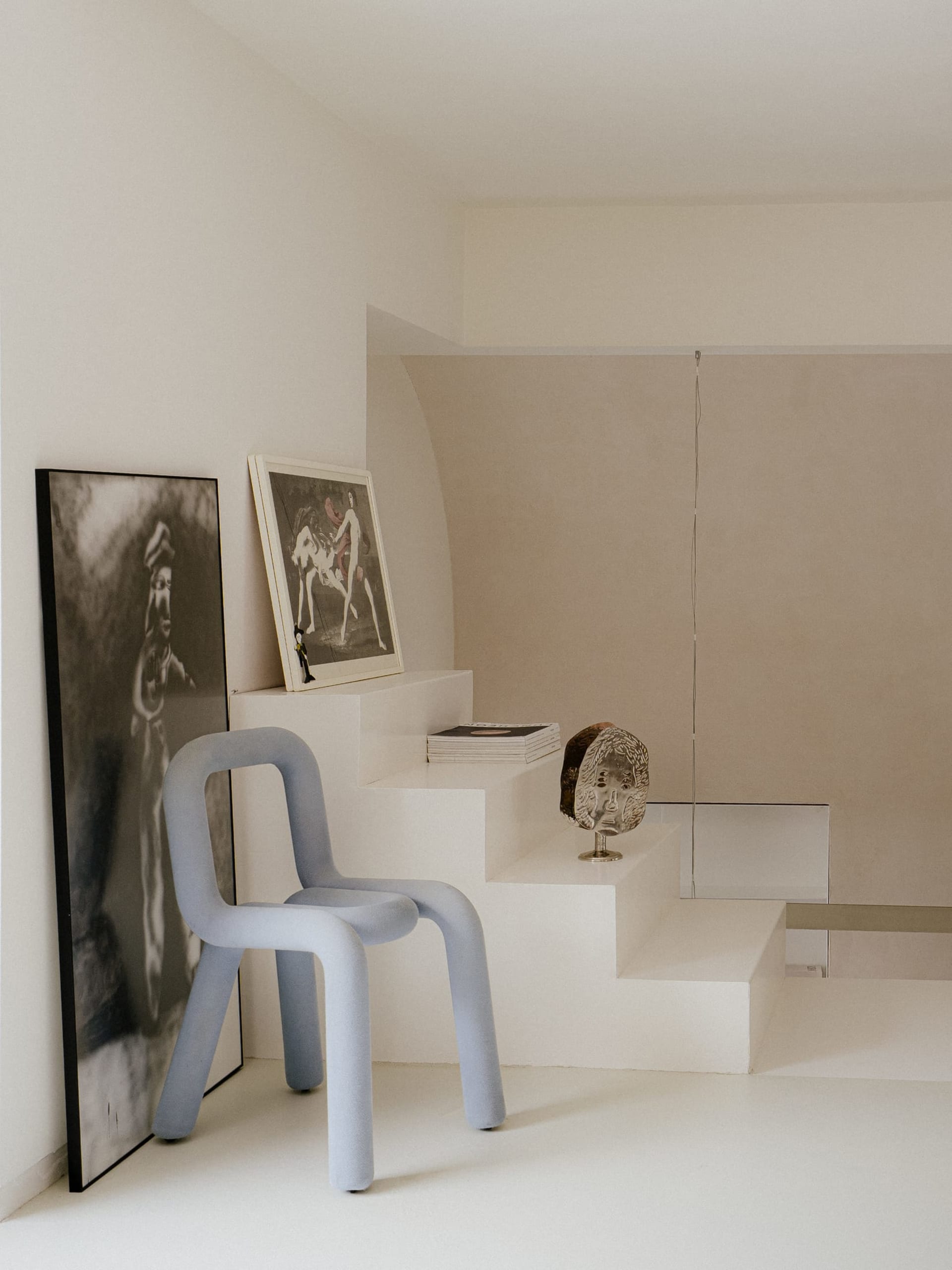Modern living space with a staircase, two chairs, and a minimalist design