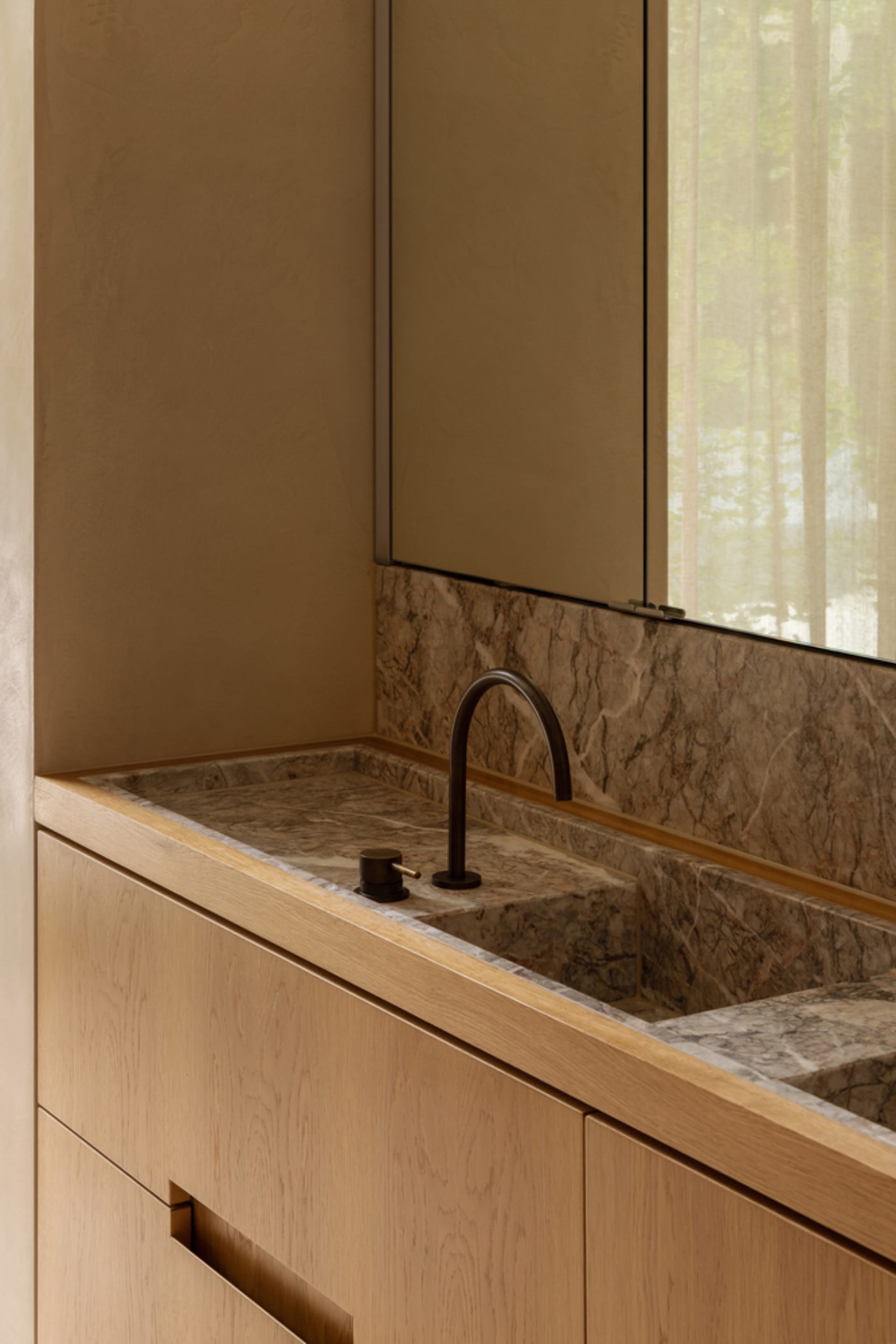 Bathroom with a marble sink, faucet, and two bottles, conveying luxury and elegance