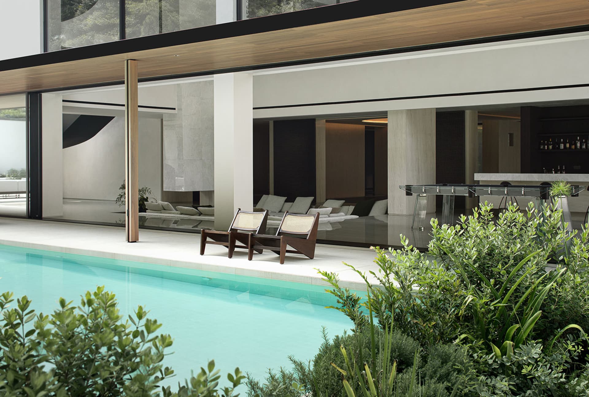 A well-lit indoor pool area with various chairs and a relaxing atmosphere