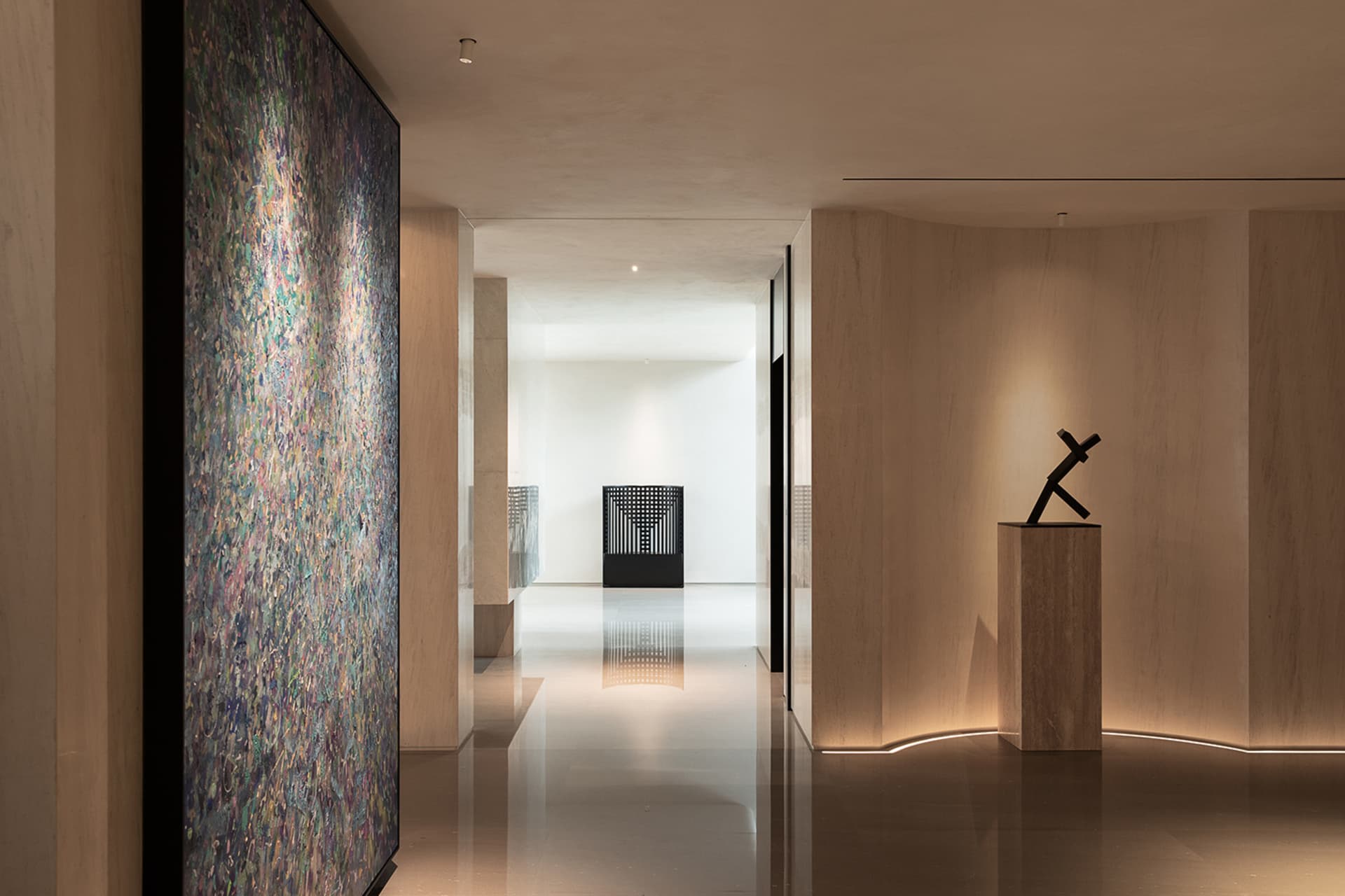 Empty modern hallway with white walls, two large paintings, and bright lighting