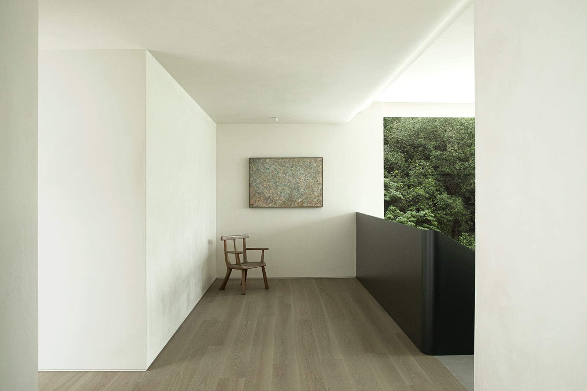 Calm and inviting living space with white walls, wooden floors, a chair, a painting, and two windows