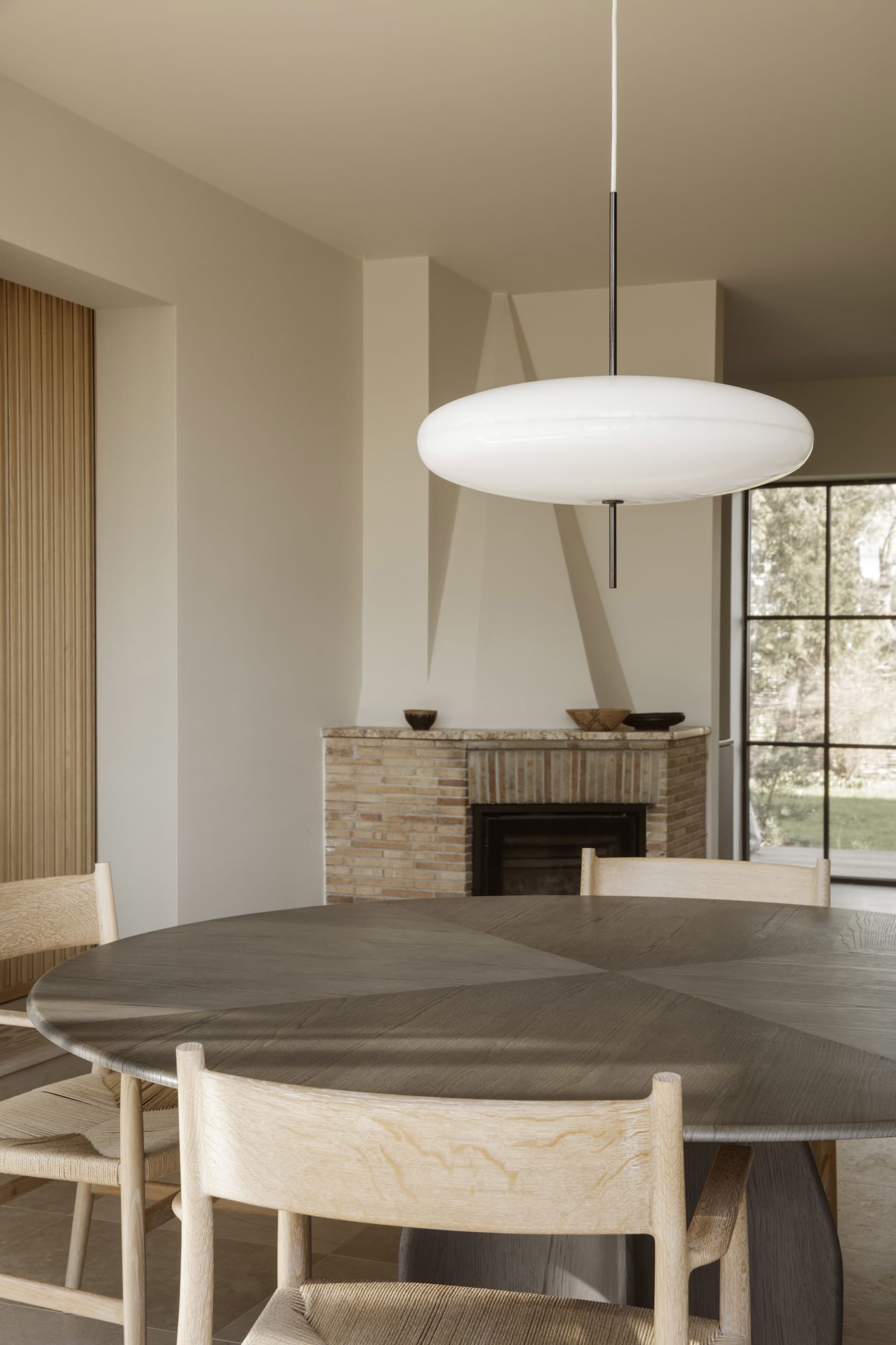 A cozy dining area with a wooden table and chairs, a fireplace, and a warm atmosphere