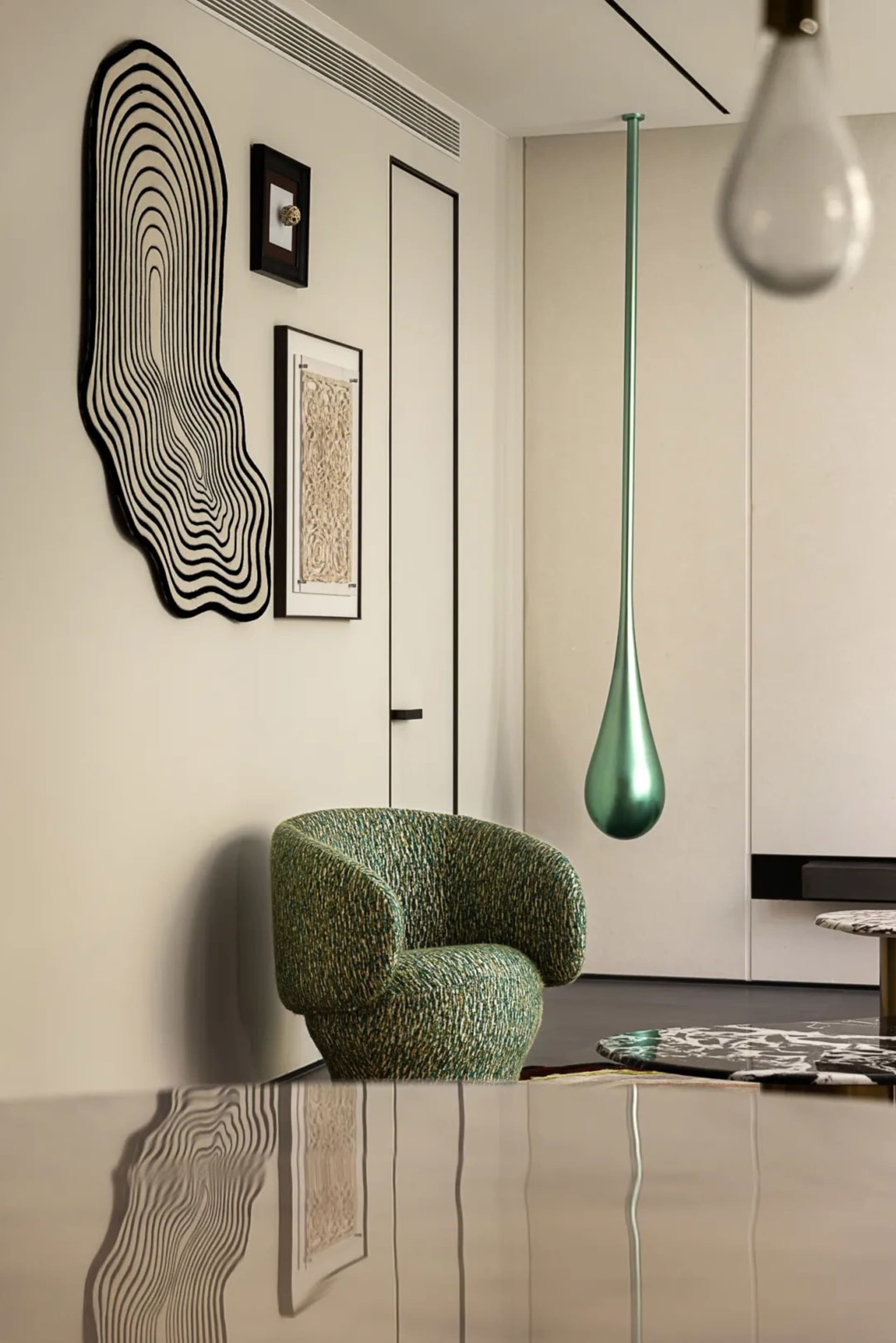 A modern living room with a green chair, two other chairs, a dining table, a vase, and a couch, with a focus on comfort and functionality