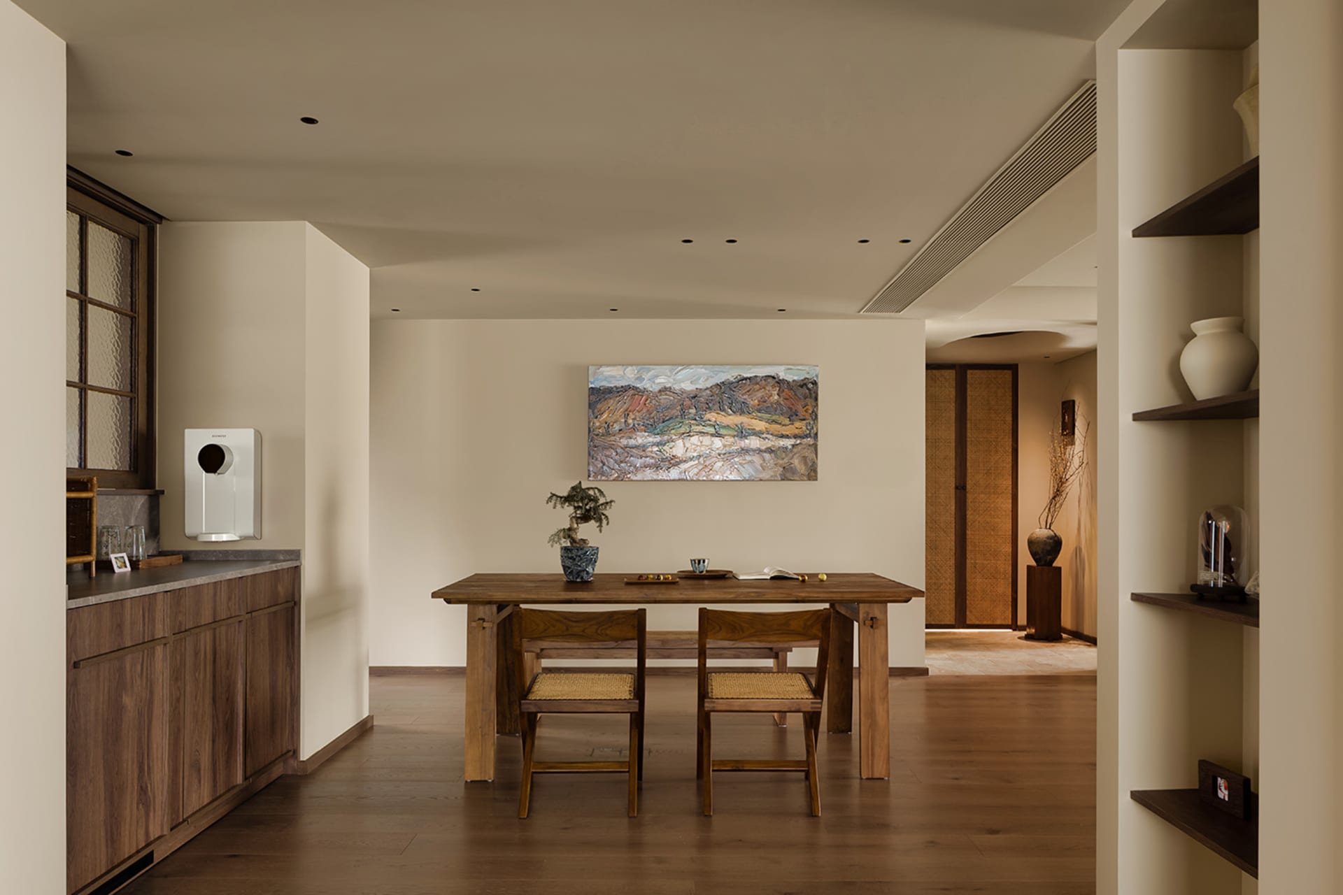 Warm and inviting open concept living space with a wooden dining table, chairs, and a potted plant