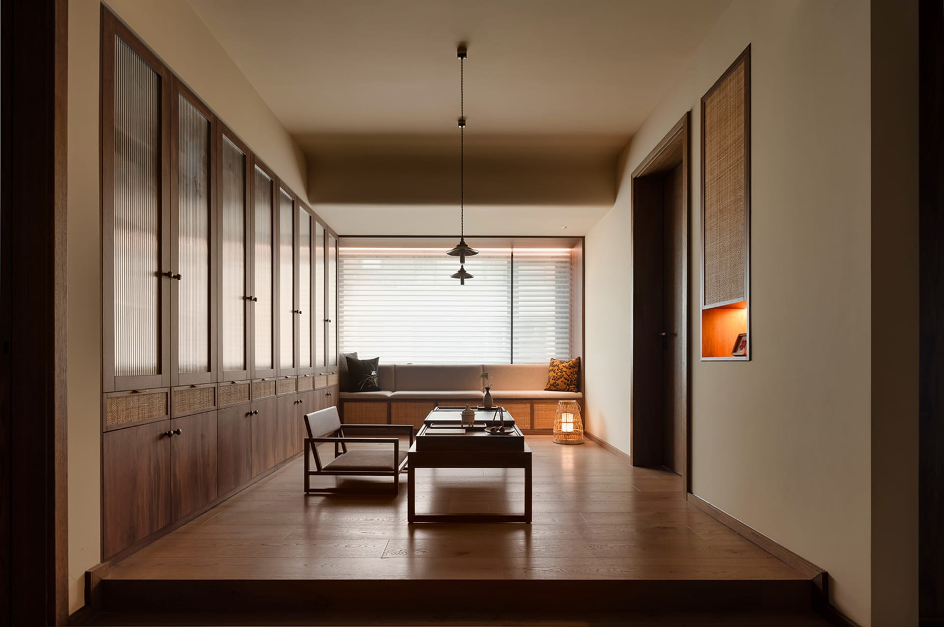Warm and inviting open living area with wooden floors and walls, featuring a dining table, chairs, and a potted plant