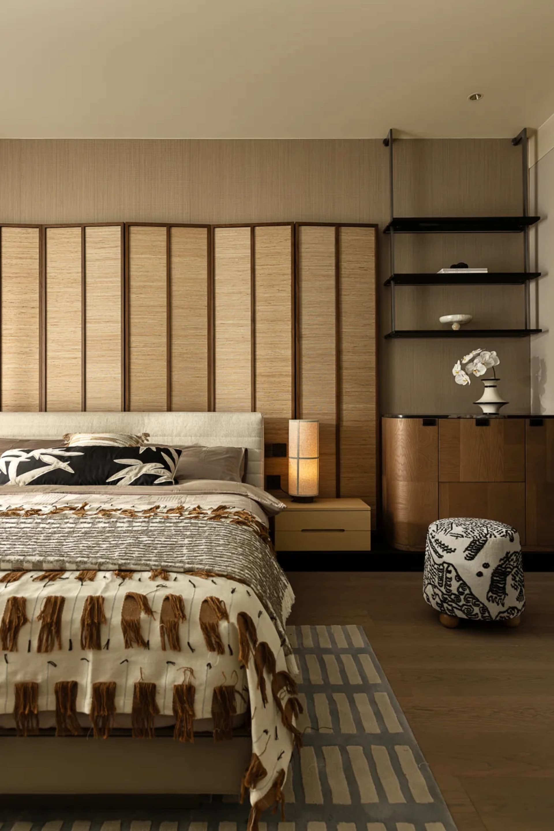 Cozy bedroom with a large bed, wooden floors and walls, and a chair, creating a warm and inviting atmosphere
