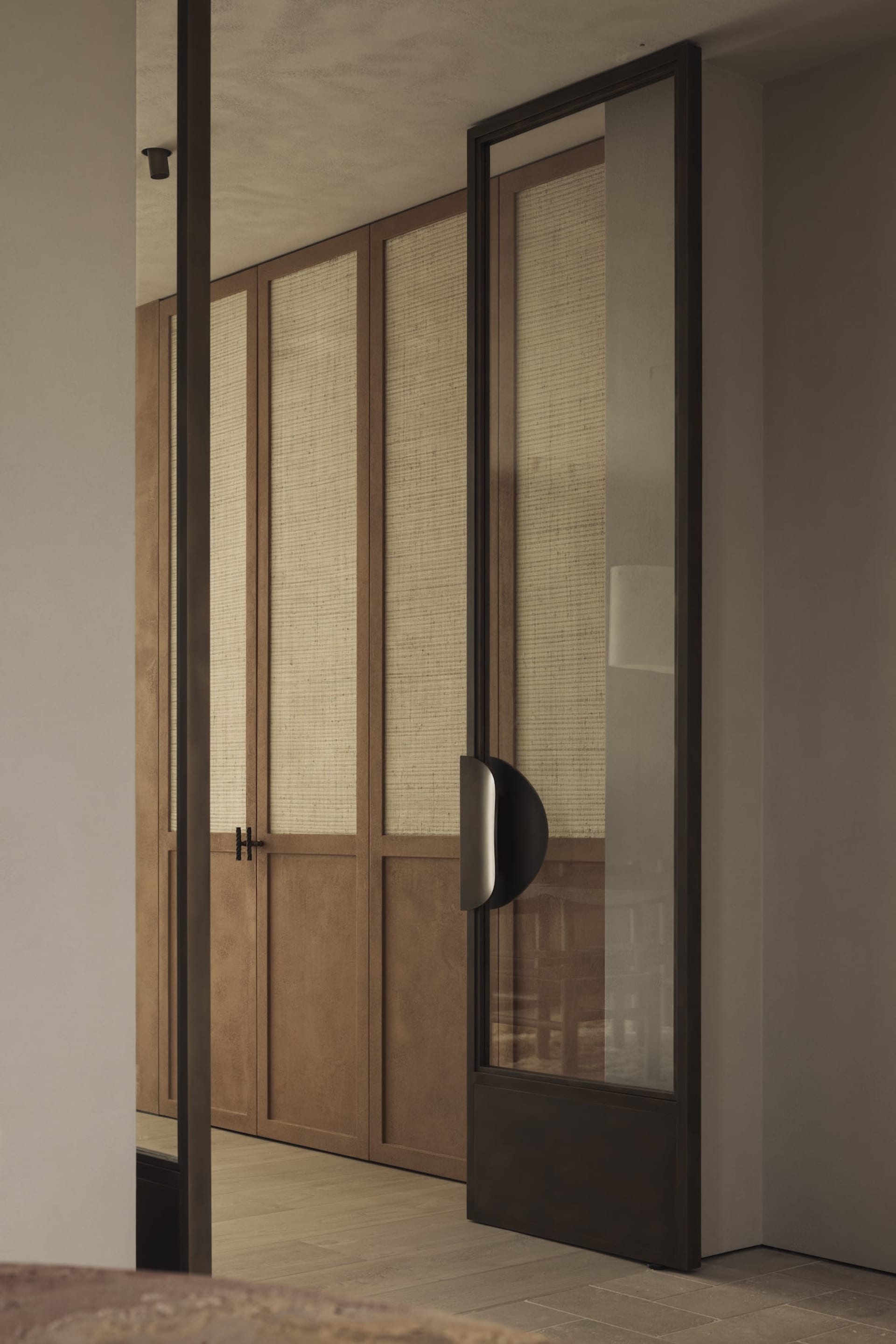 A calm and inviting interior hallway with a wooden door and a glimpse of the hallway beyond