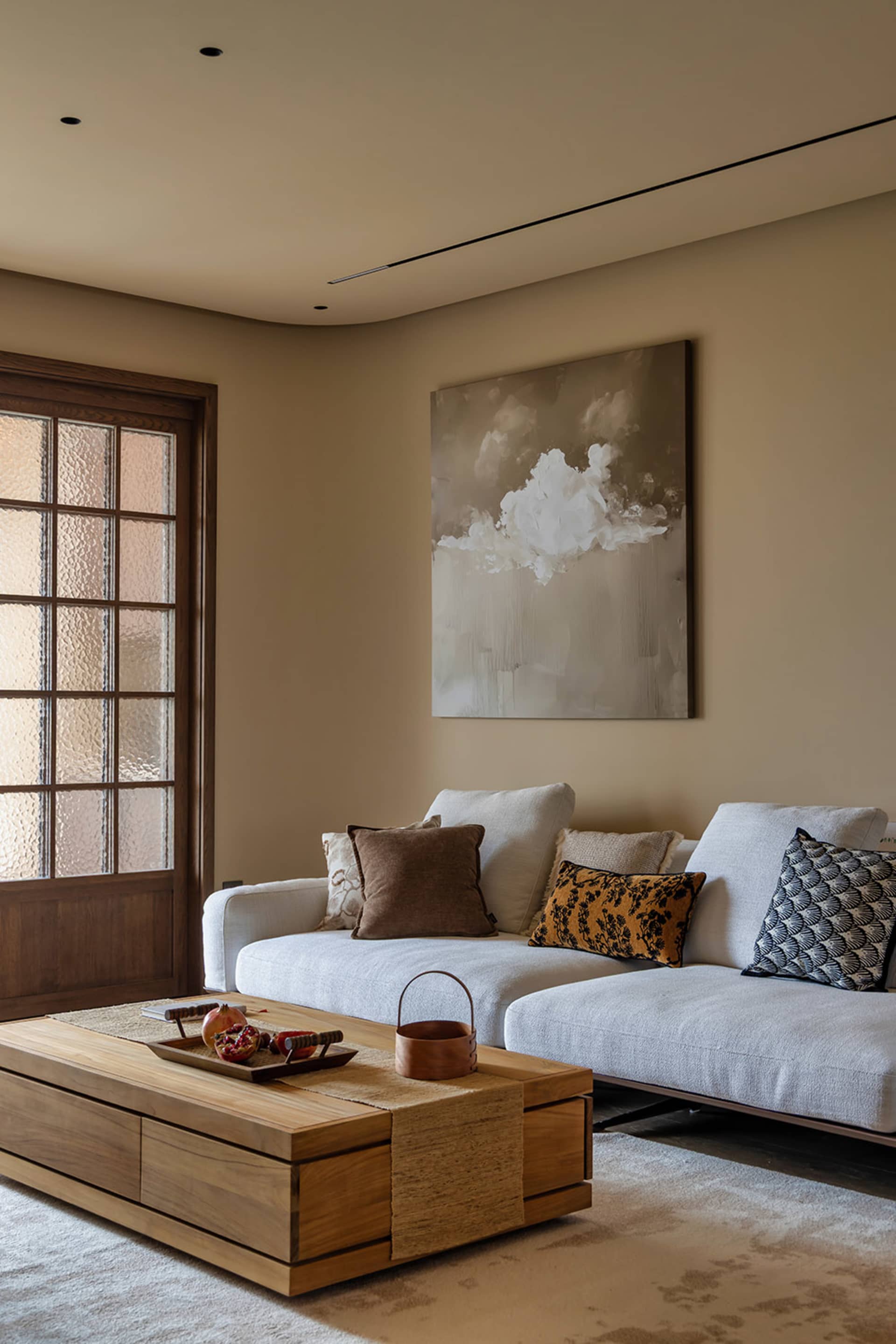 A warm and inviting living room with two couches, chairs, and a wooden table, featuring pillows and a cozy atmosphere