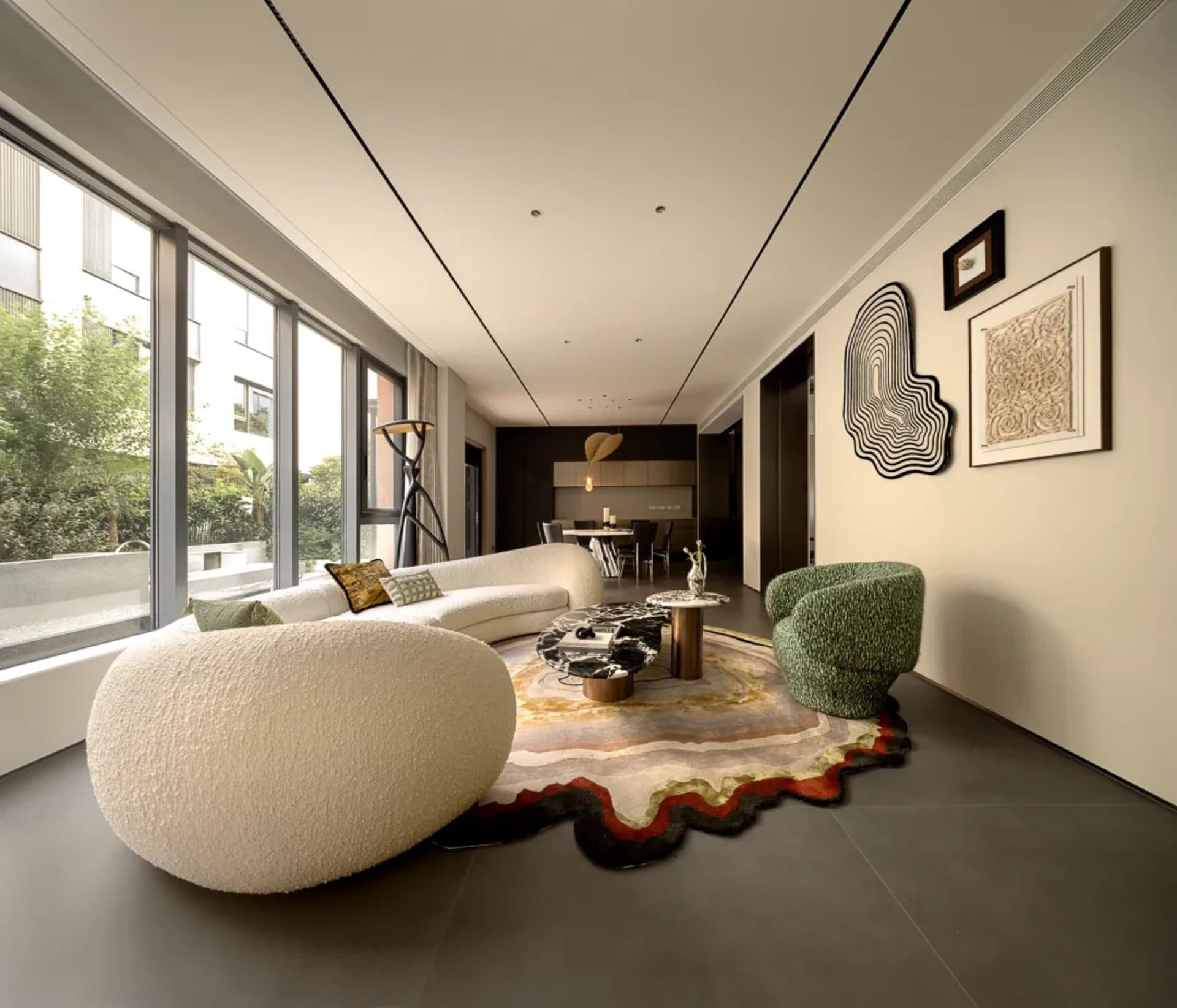 Open living area with modern furniture, tile flooring, and large windows allowing natural light
