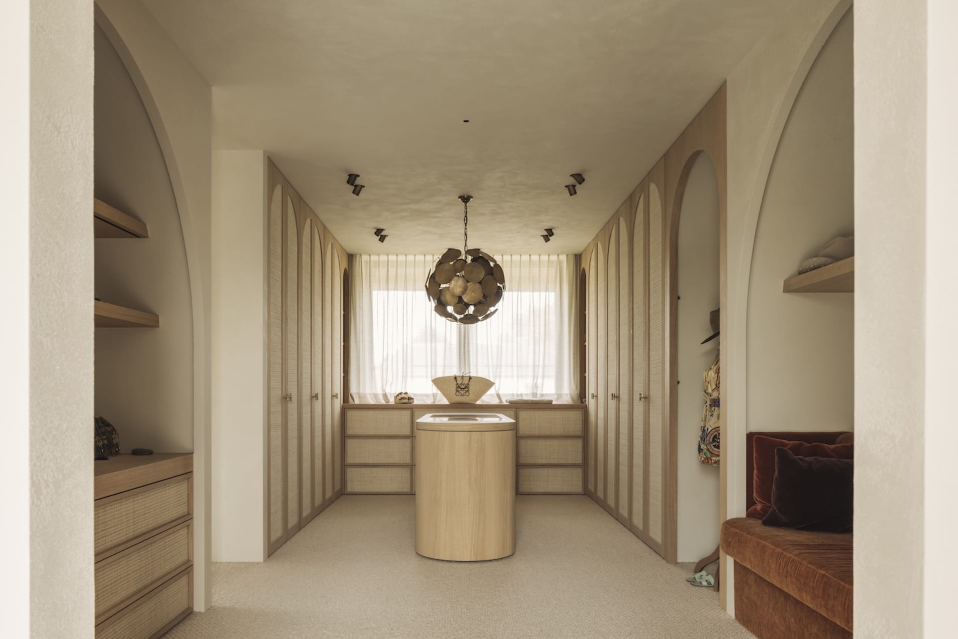 Bathroom with wooden floors and walls, natural light, and a chandelier, creating a clean and inviting atmosphere